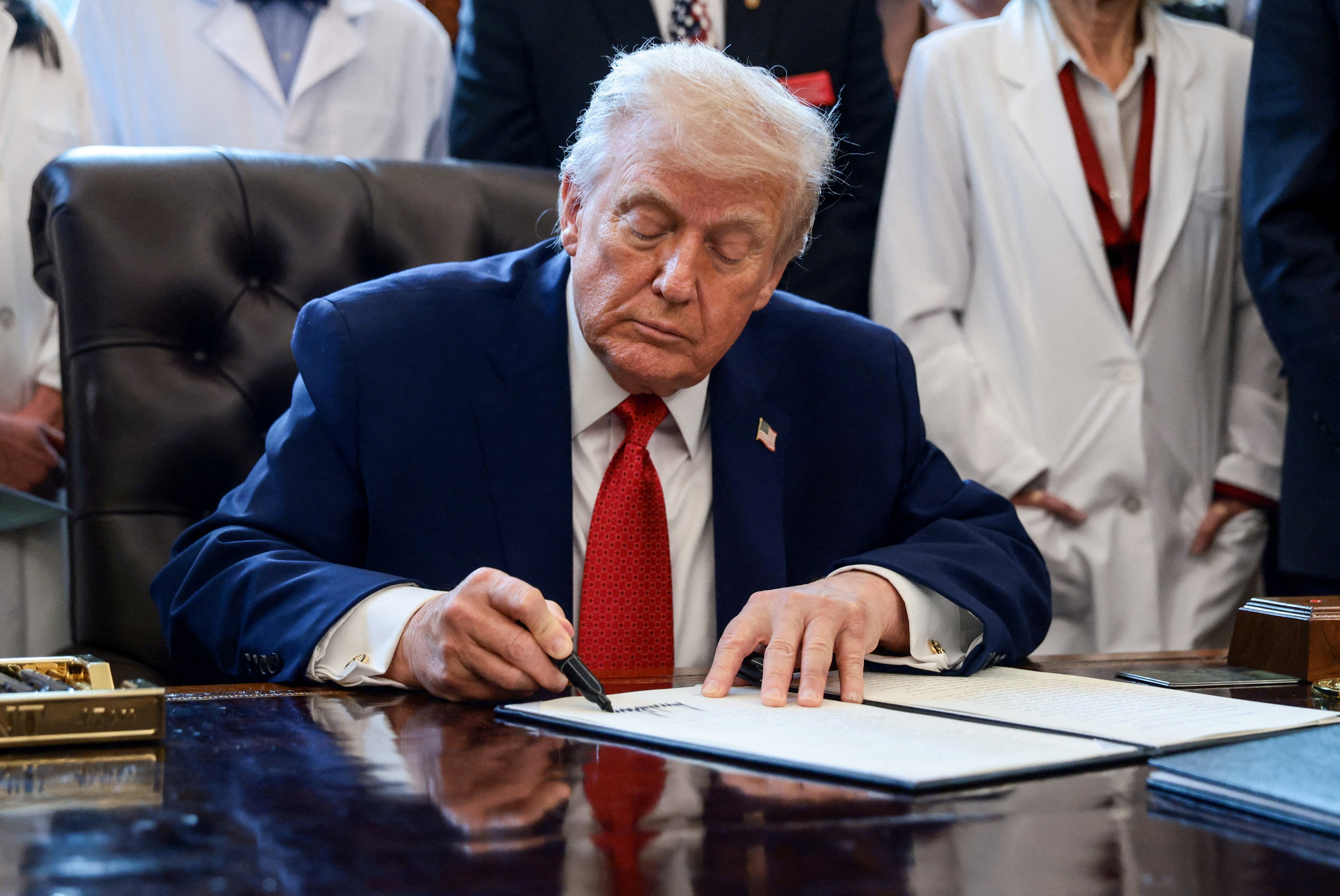 US President Donald Trump signs an executive order recommending loosening the federal regulations on marijuana, in the Oval Office on December 18, 2025. Photo: Reuters