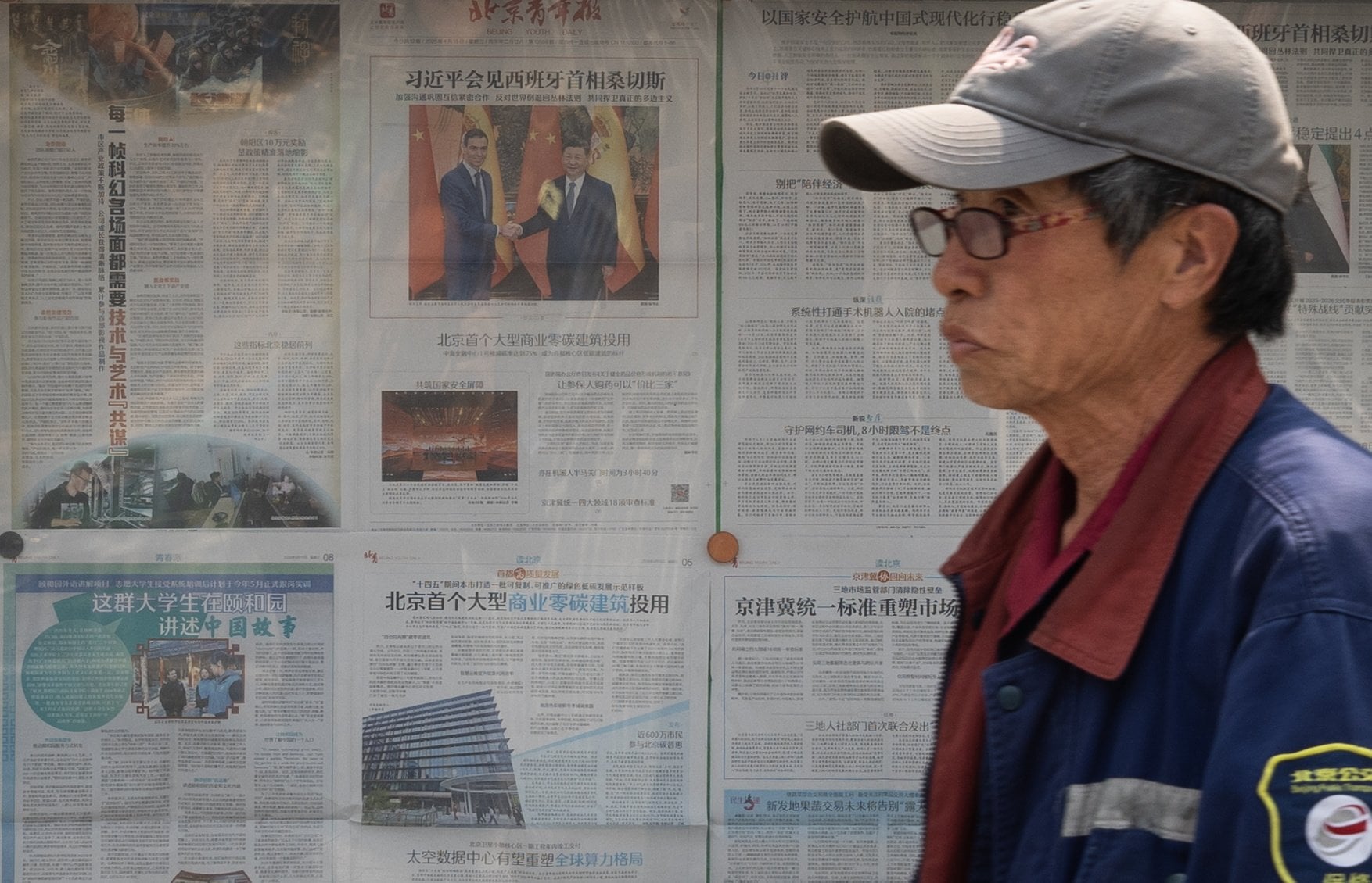 A man walks past a Chinese newspaper featuring a photo of Spanish Prime Minister Pedro Sanchez and Chinese President Xi Jinping in Beijing on April 15. Photo: EPA