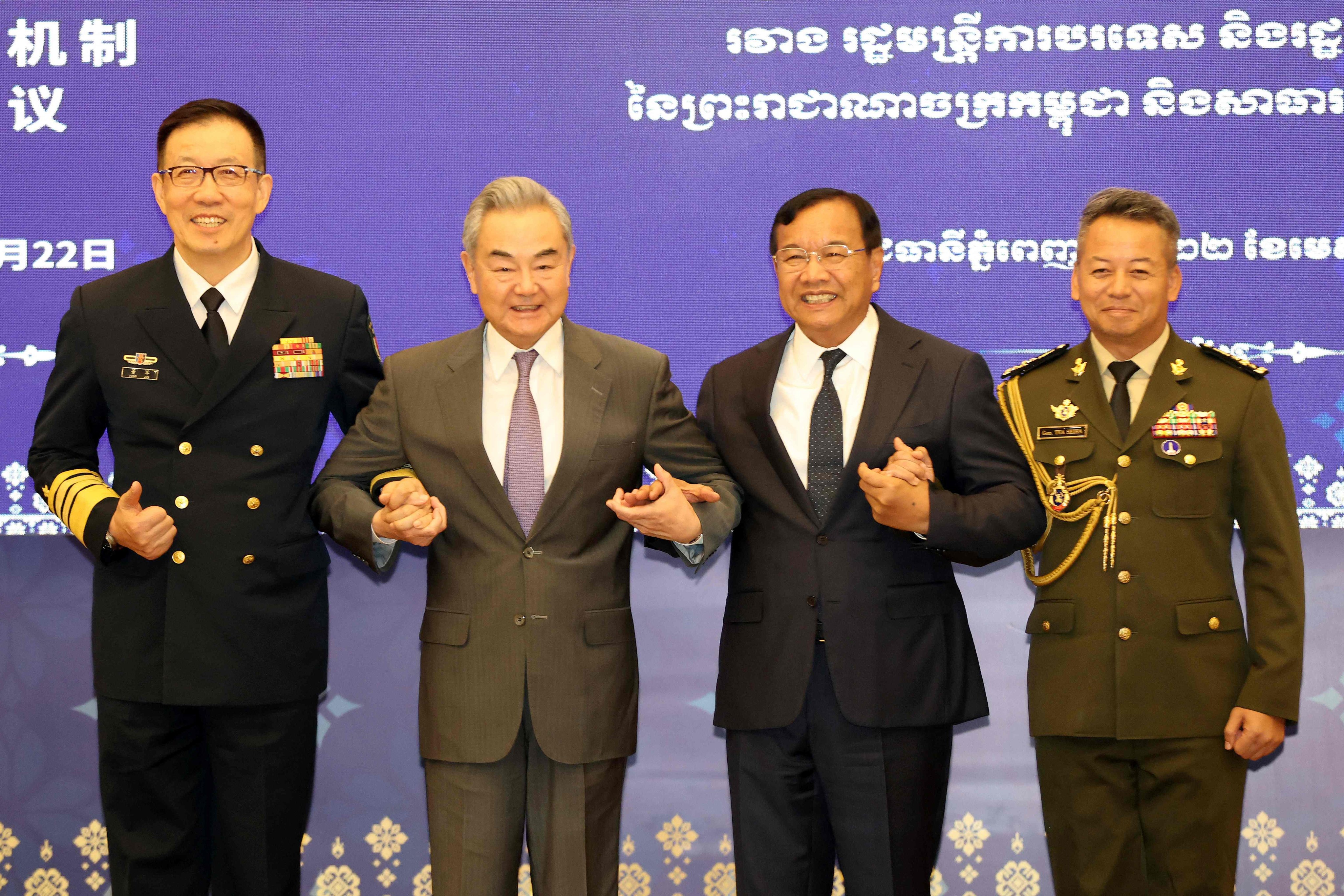 China’s Defence Minister Dong Jun and Foreign Minister Wang Yi link arms with Prak Sokhonn, Cambodian Deputy Prime Minister and Minister of Foreign Affairs and International Cooperation, and Cambodia’s Defence Minister General Tea Seiha. Photo: Handout/Agence Kampuchea Press