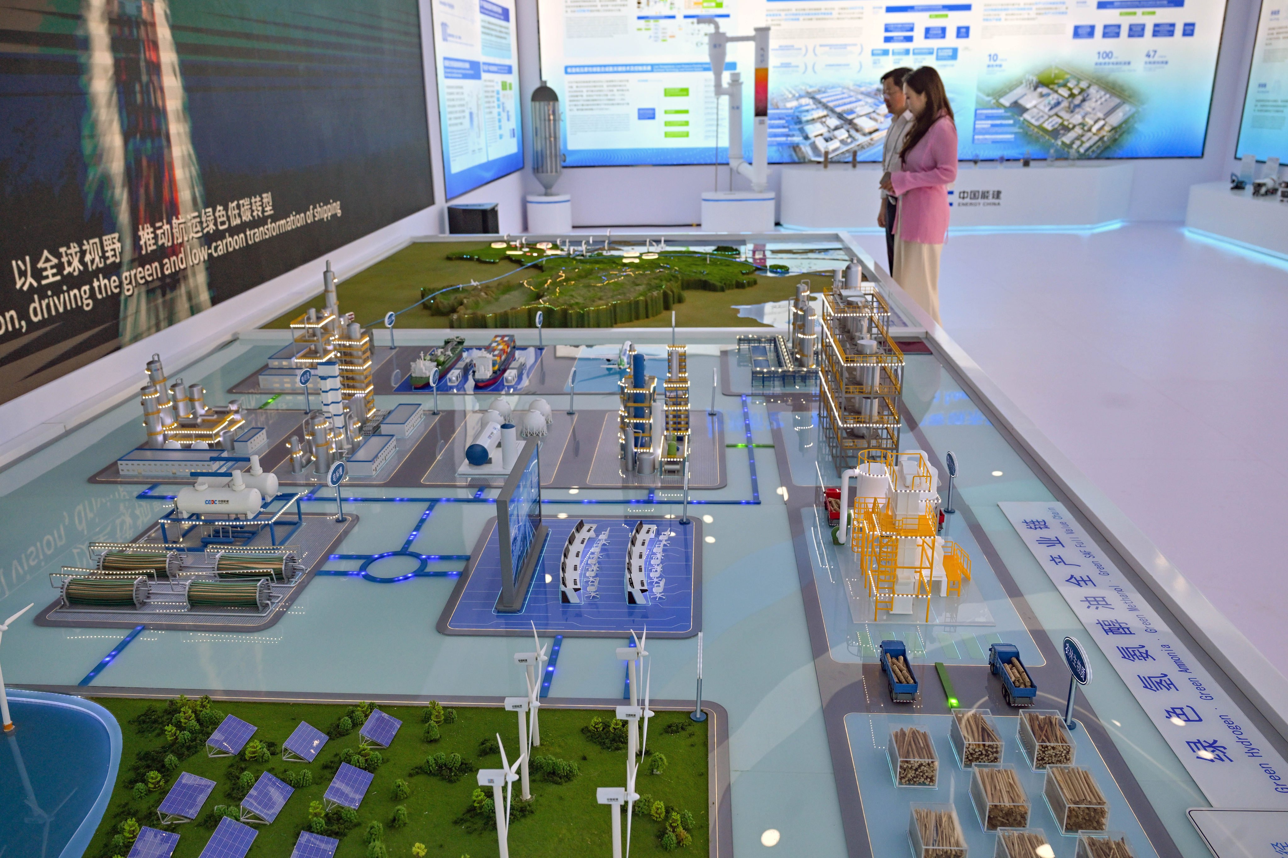 A couple looks at a model of the entire industrial chain of green hydrogen, ammonia, methanol, and oil displayed at the China Energy Engineering Group pavilion in Boao on March 25. Photo: Xinhua