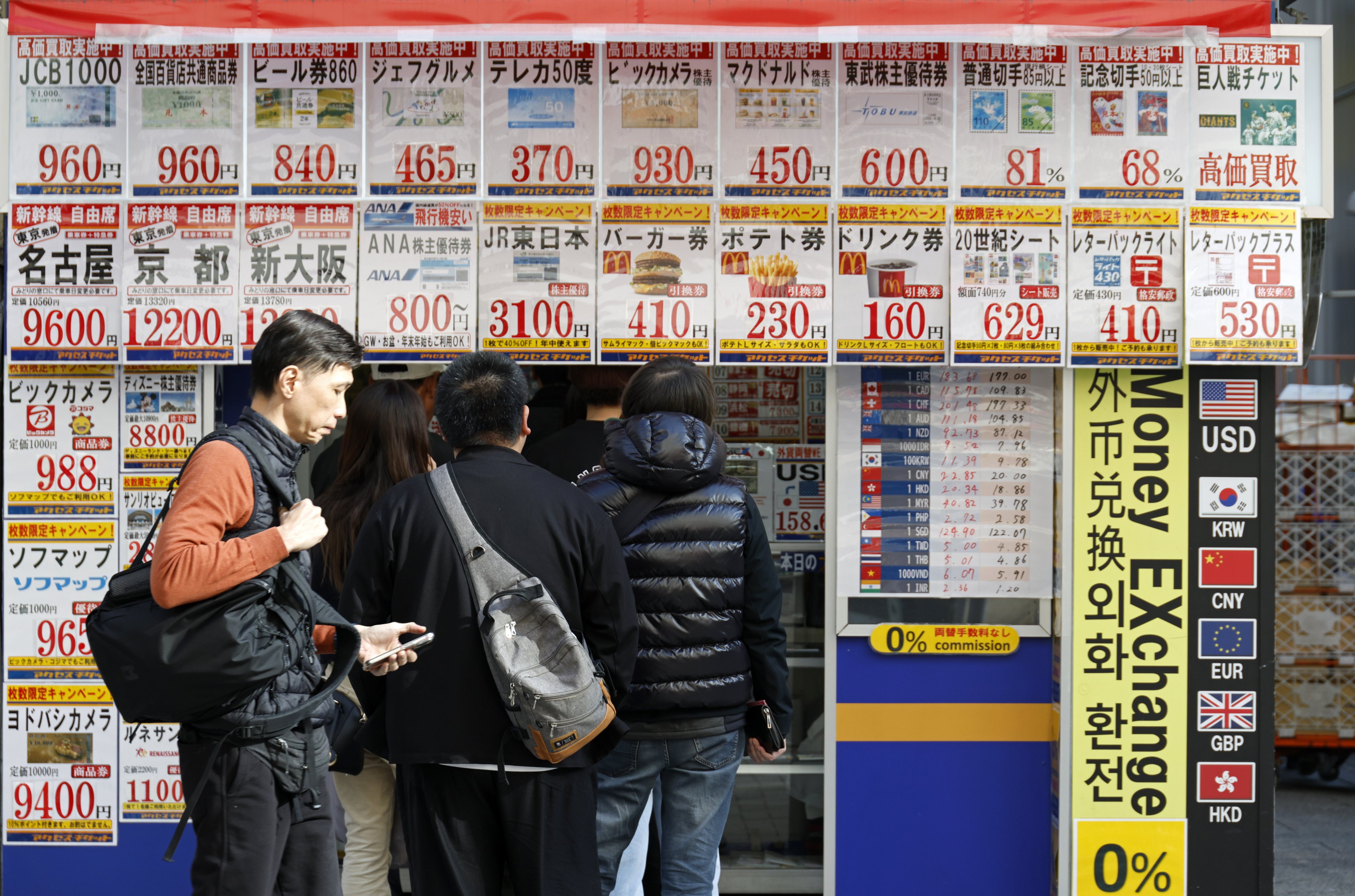 Customers queue at a discount ticket shop at Akihabara Electric Town in Tokyo on March 24. The weak yen is fuelling inflation by increasing the cost of imported goods, sapping consumers’ purchasing power and making it harder to tackle Japan’s cost-of-living crisis. Photo: EPA