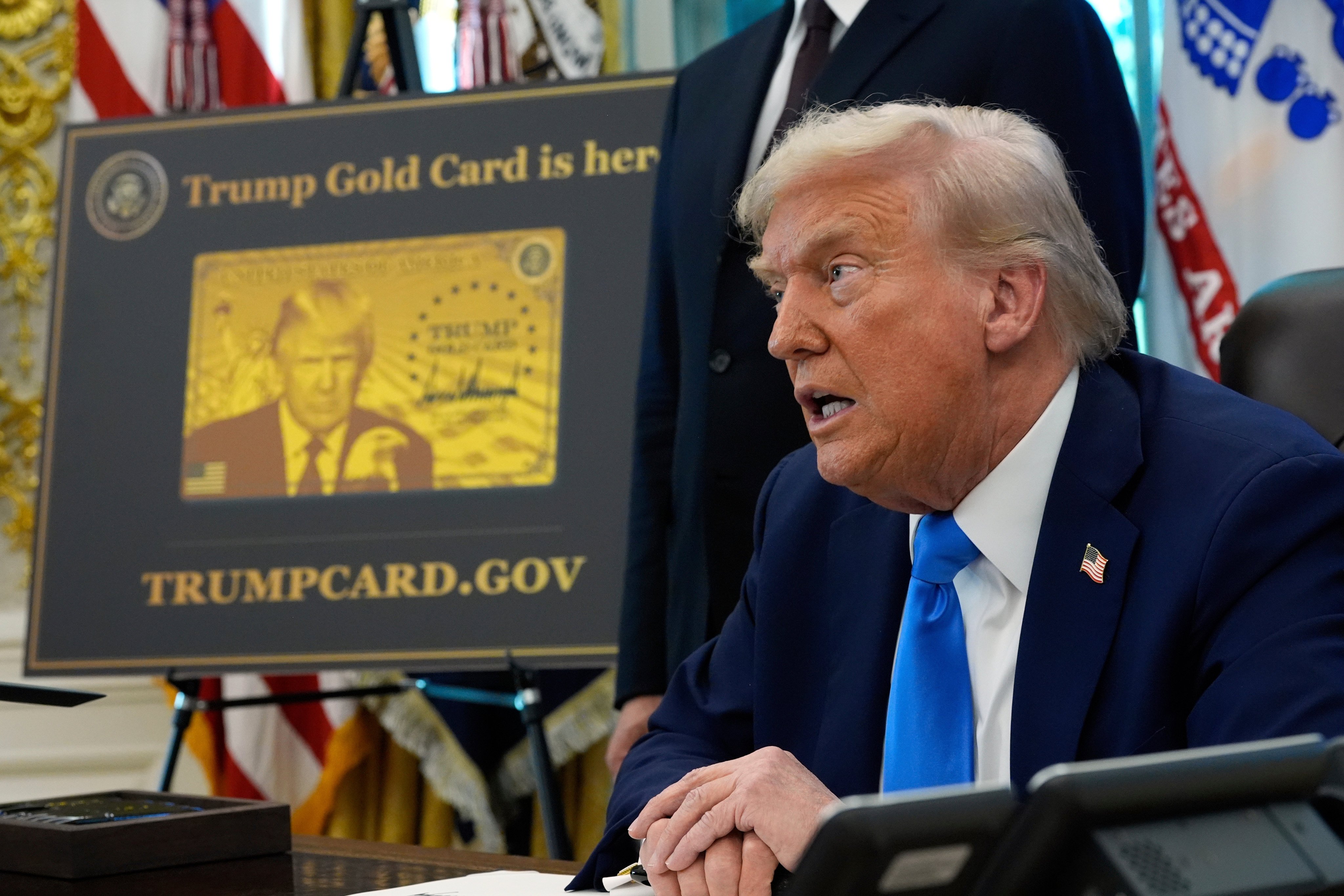 A poster showing the Trump Gold Card is seen as US President Donald Trump signs executive orders in the Oval Office in September 2025. Photo: AP