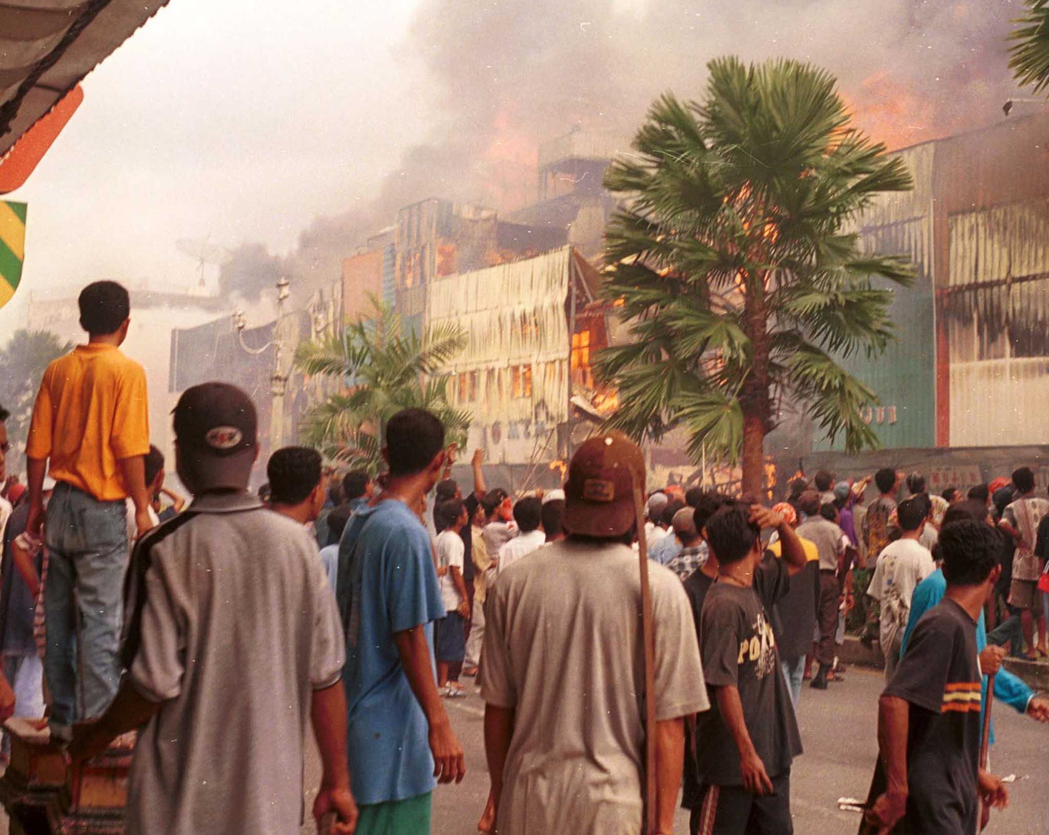 A crowd watched a burning shopping centre in Ambon in 1999 amid clashes between Christians and Muslims that had killed hundreds in the Indonesian city that year. Photo: Reuters
