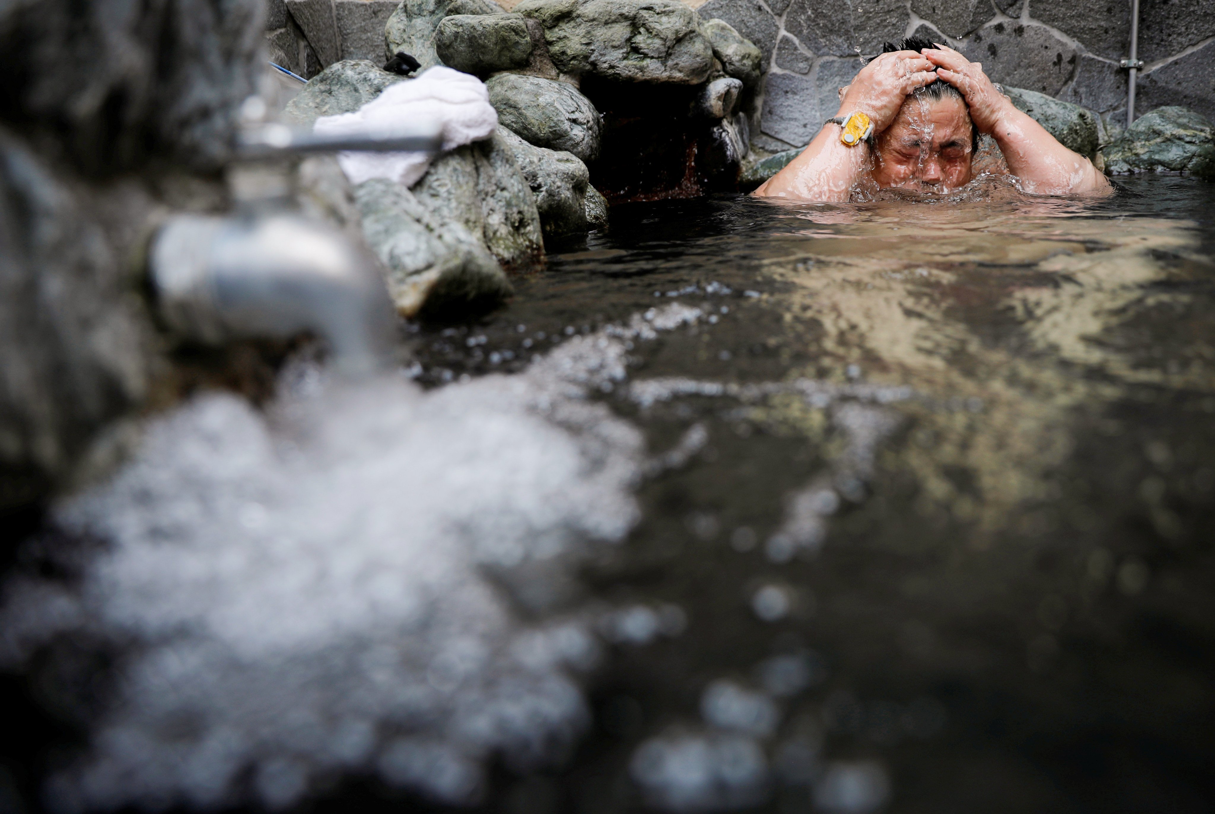 A customer soaks himself in a bath at a public bathhouse in Tokyo. Photo: Reuters