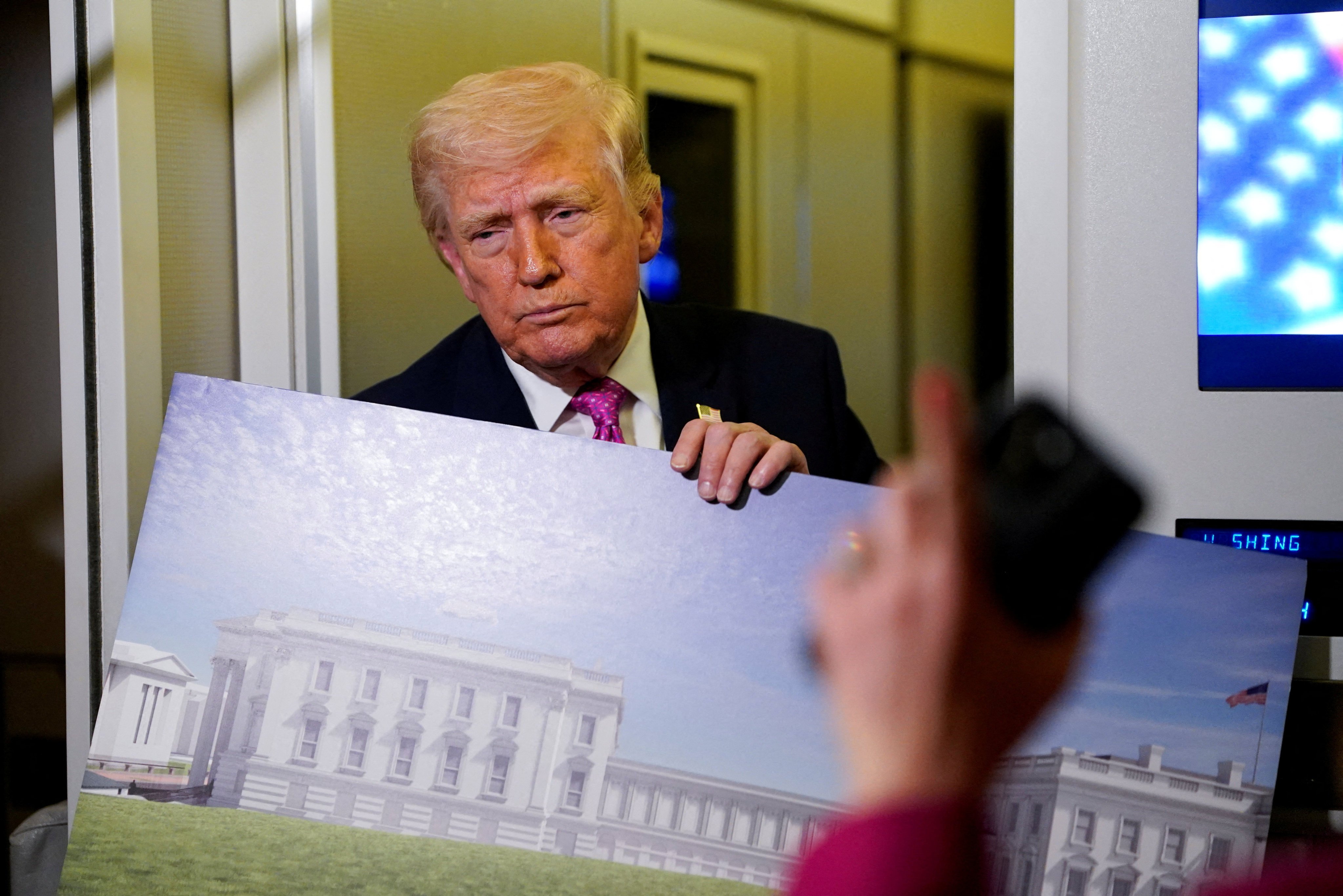US President Donald Trump holds up renderings of the planned White House ballroom, aboard Air Force One in March. Photo: Reuters