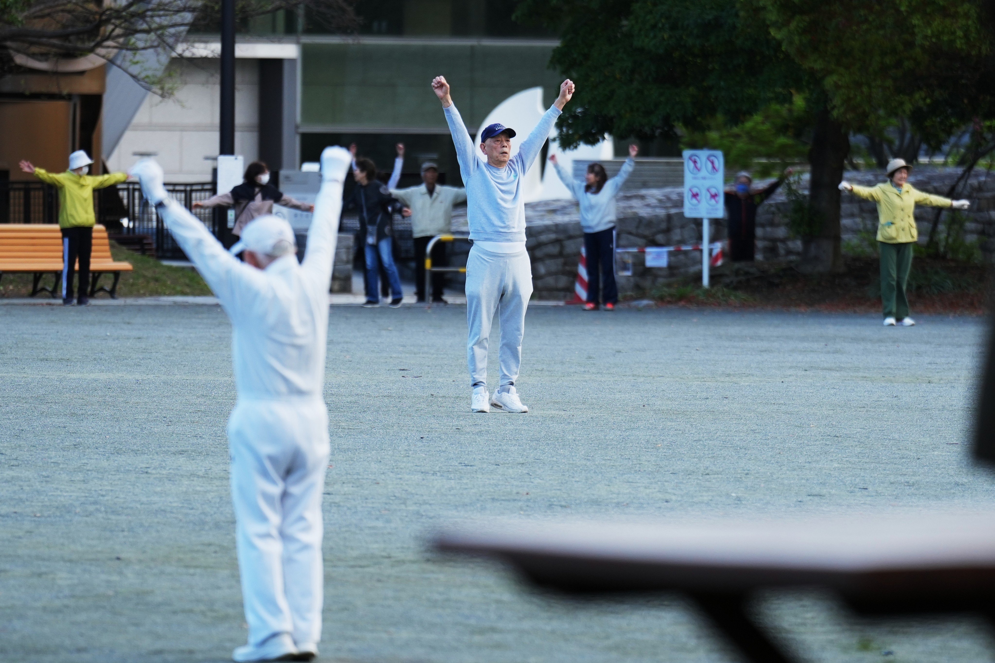 People perform a stretching exercise while listening to a Radio Taiso programme in a public park in Tokyo, Japan, on April 6, 2026. Photo: AP