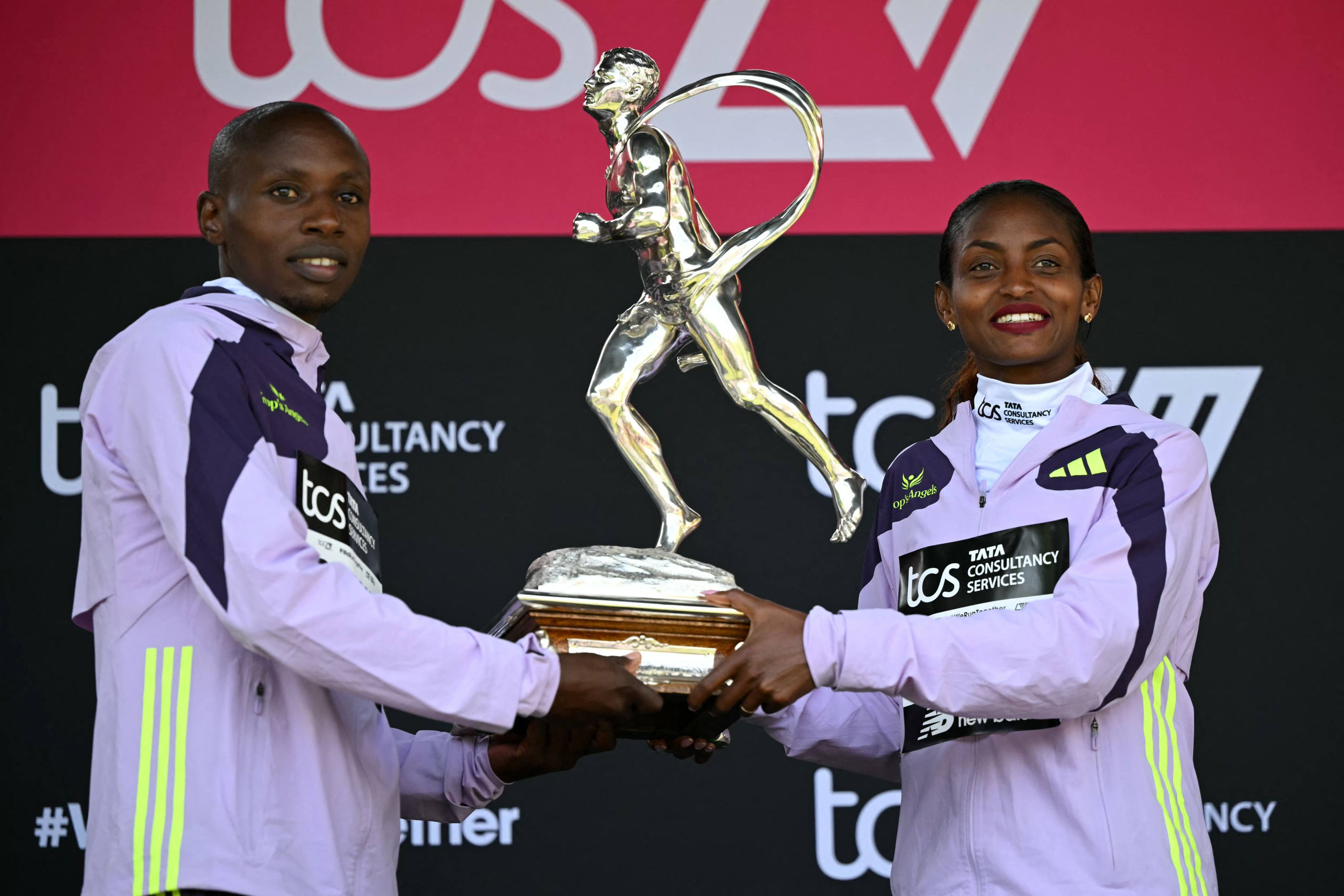 Marathon winners Sabastian Sawe (left) and Tigst Assefa with the Chris Brasher Sporting Life Trophy  in London. Photo: AFP