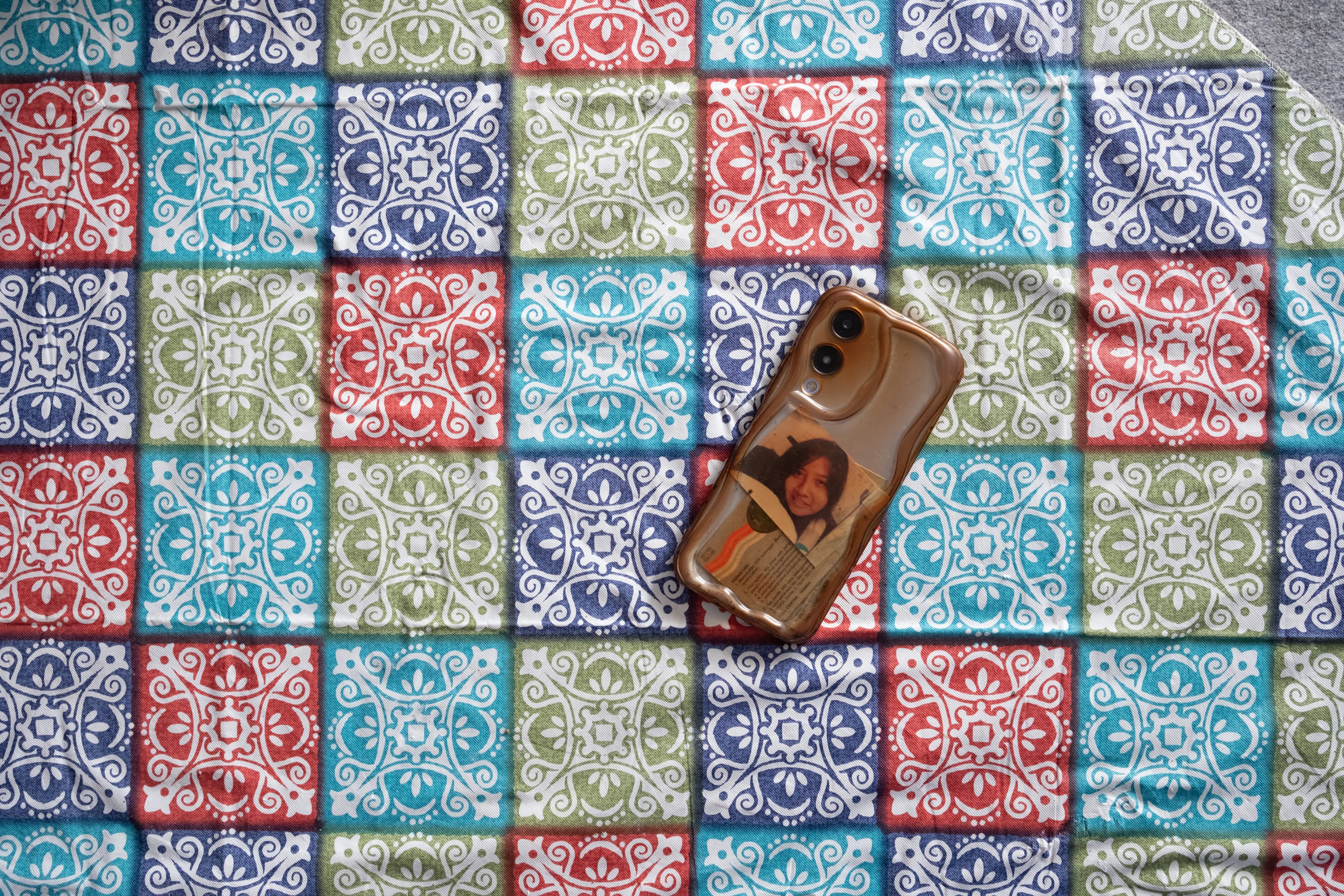 The brother of Desy Widyana keeps a picture of his late sister in his mobile phone case. Photo: Tang Hoi-yan