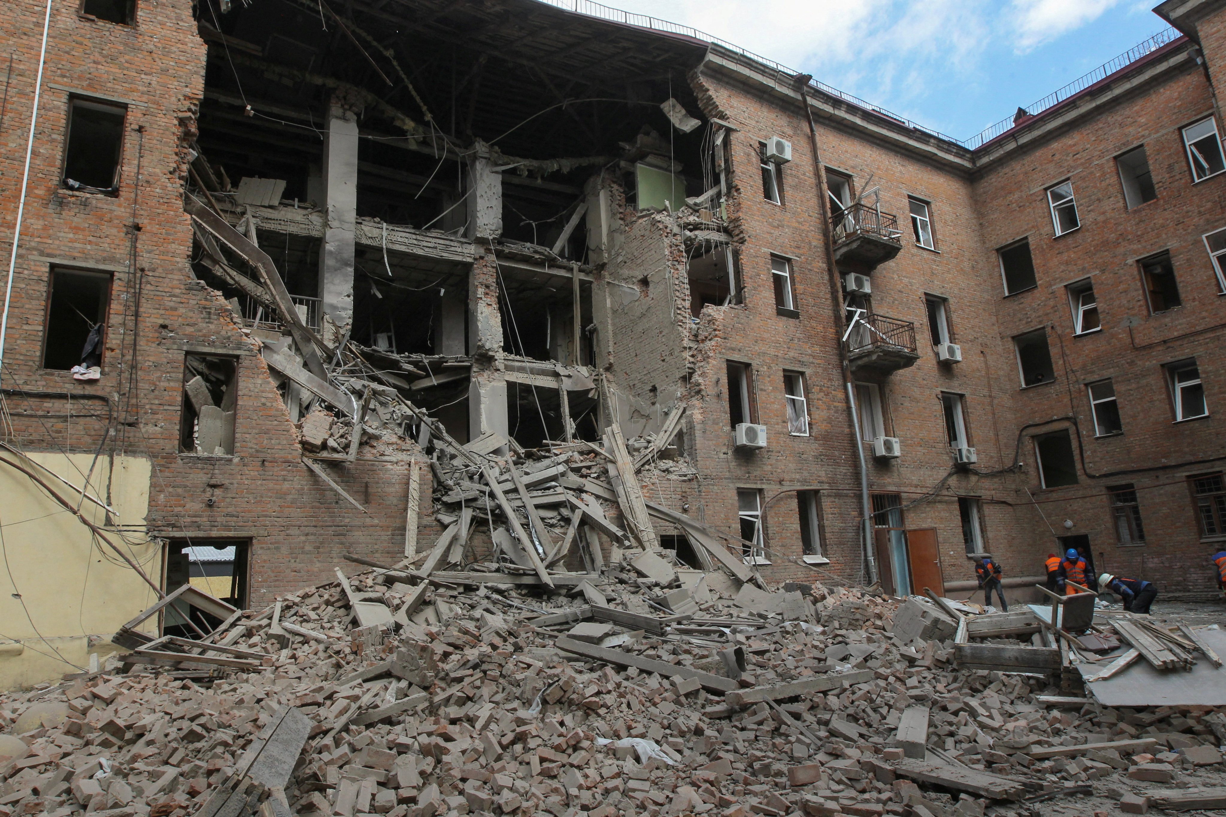 Municipal workers remove debris at the site of a residential building hit during a Russian drone strike in Dnipro, Ukraine at the weekend. Photo: Reuters