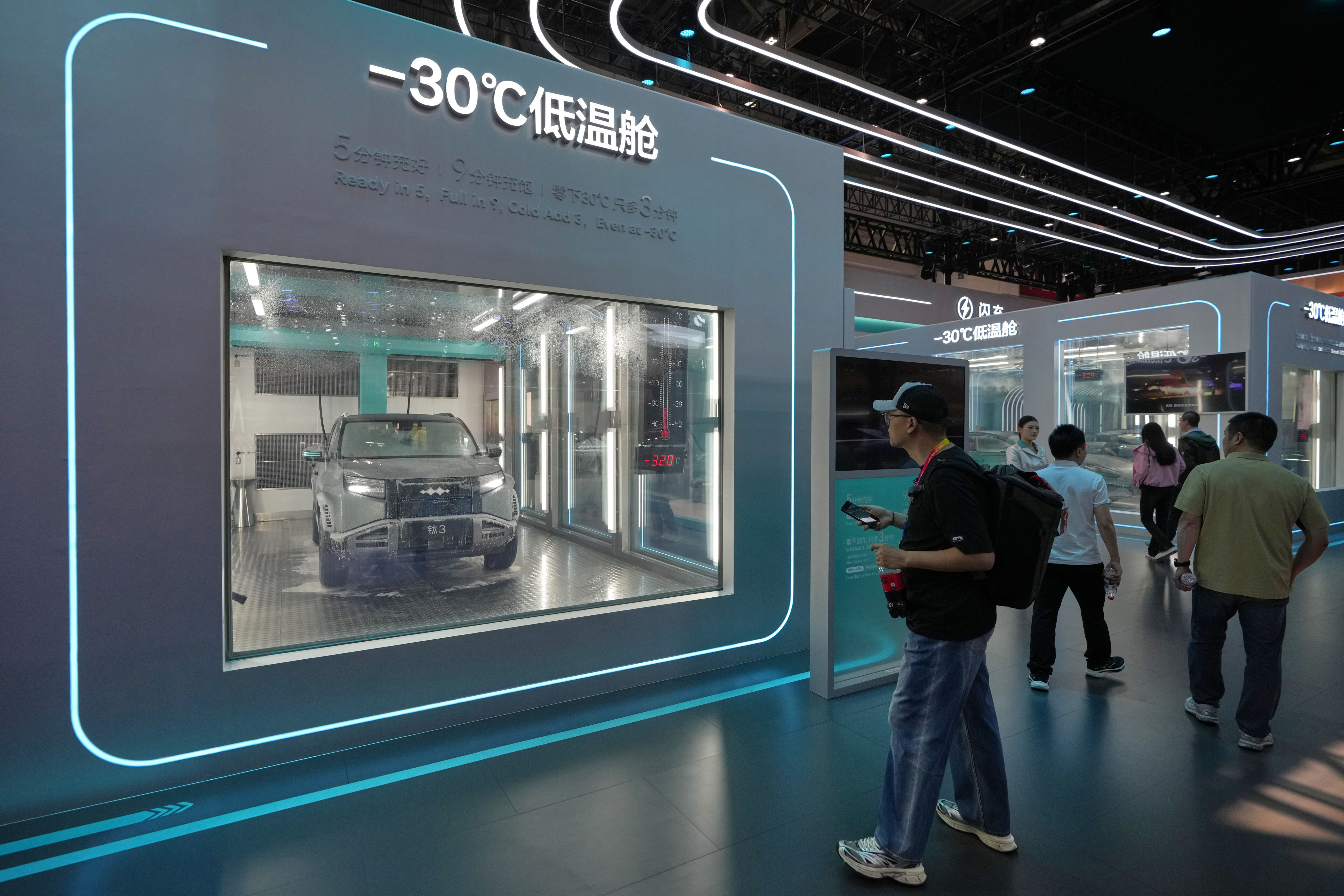 Visitors look at a chamber with sub-zero temperatures that showcases battery-charging technology at the Beijing Auto Show. Photo: AP