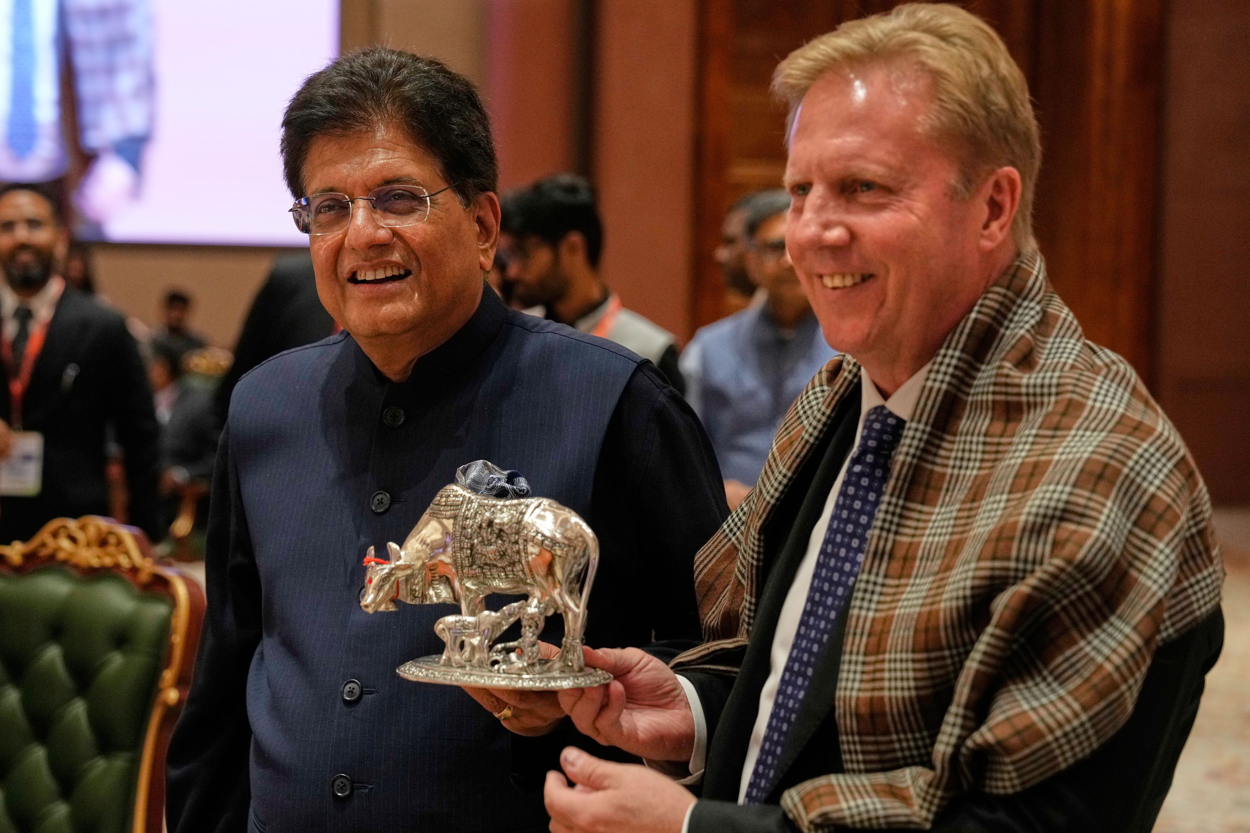 Indian Commerce Minister Piyush Goyal presents a silver cow and calf statue to New Zealand Trade Minister Todd McClay after they signed a free-trade agreement in New Delhi on Monday. Photo: AP