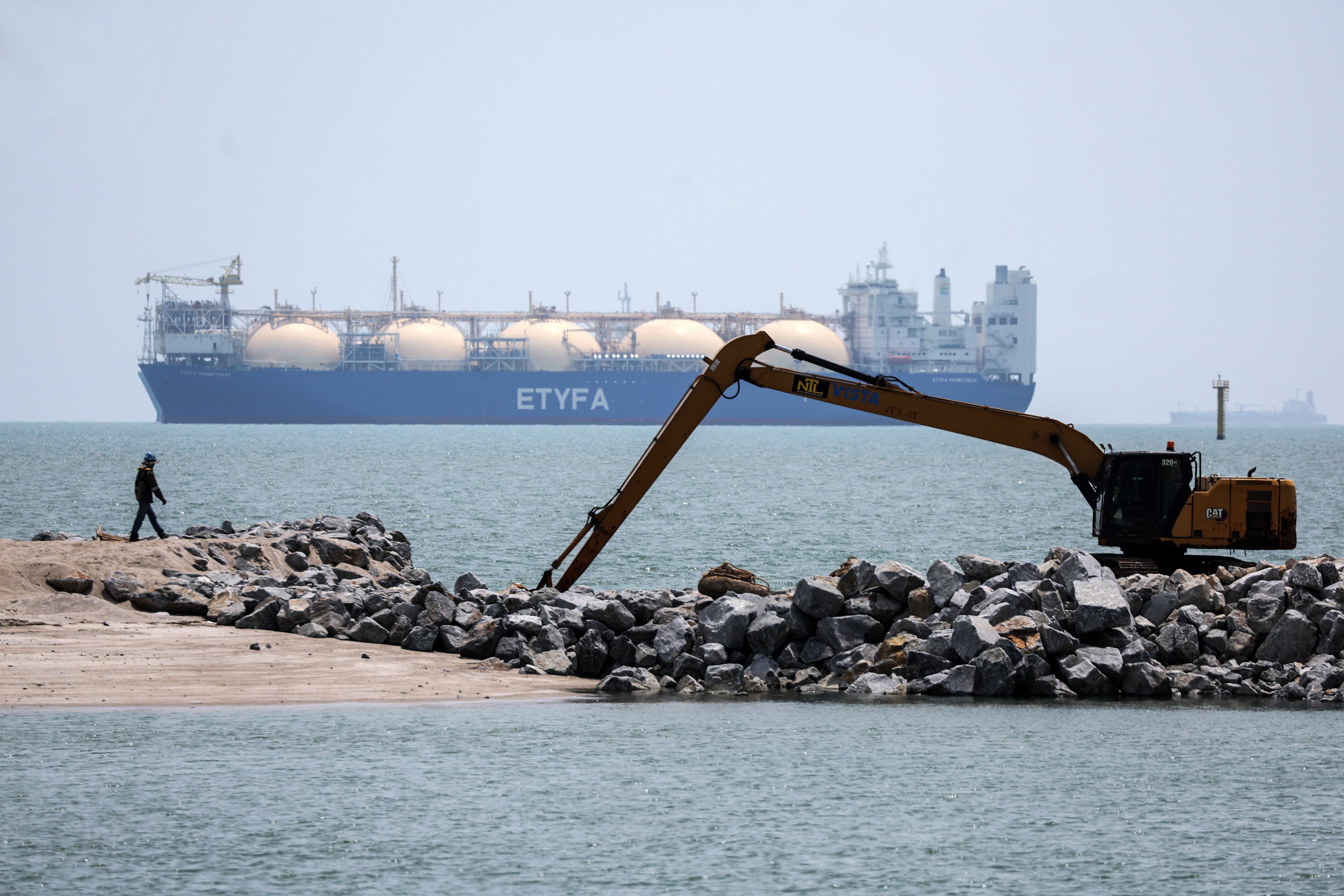 A worker walks past a liquefied natural gas tanker in the Malacca Strait on April 15. Photo: EPA