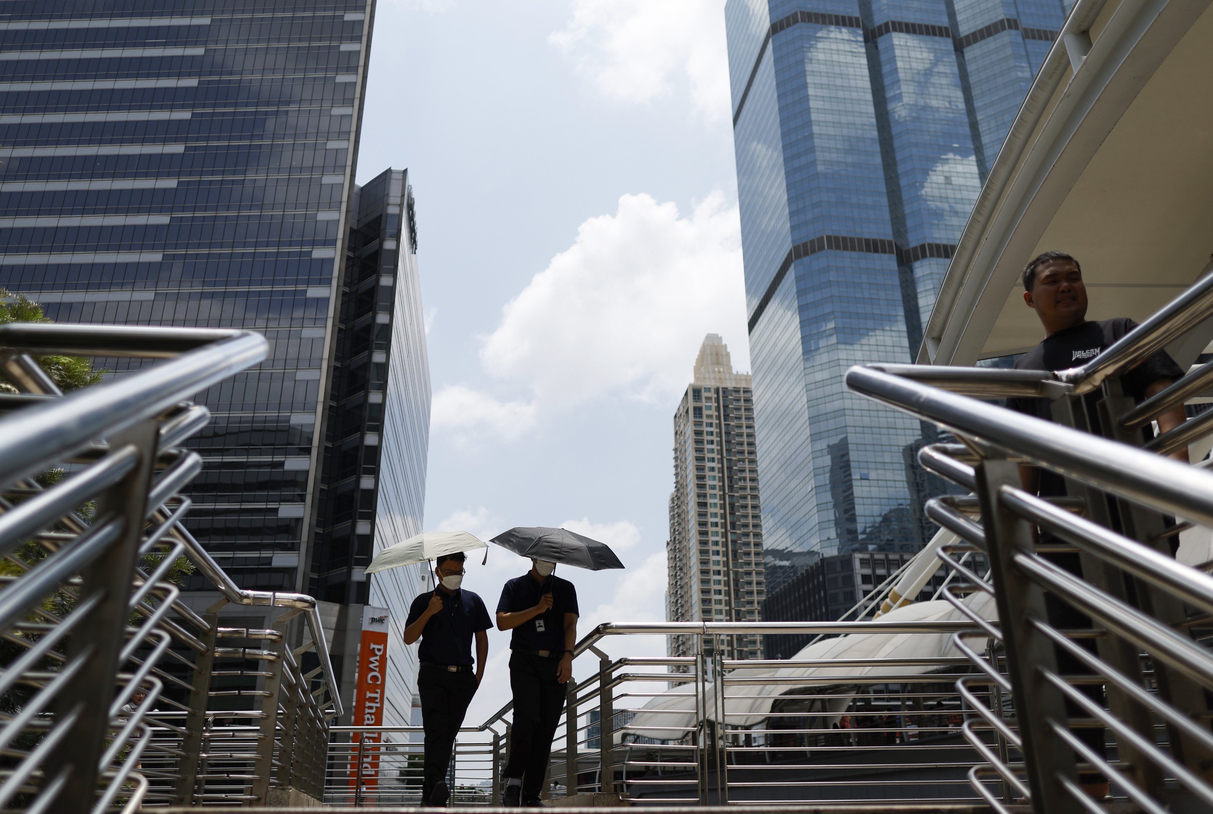 Office workers walk with umbrellas to shield themselves from the sun during hot weather in Bangkok, Thailand, last month. Photo: EPA
