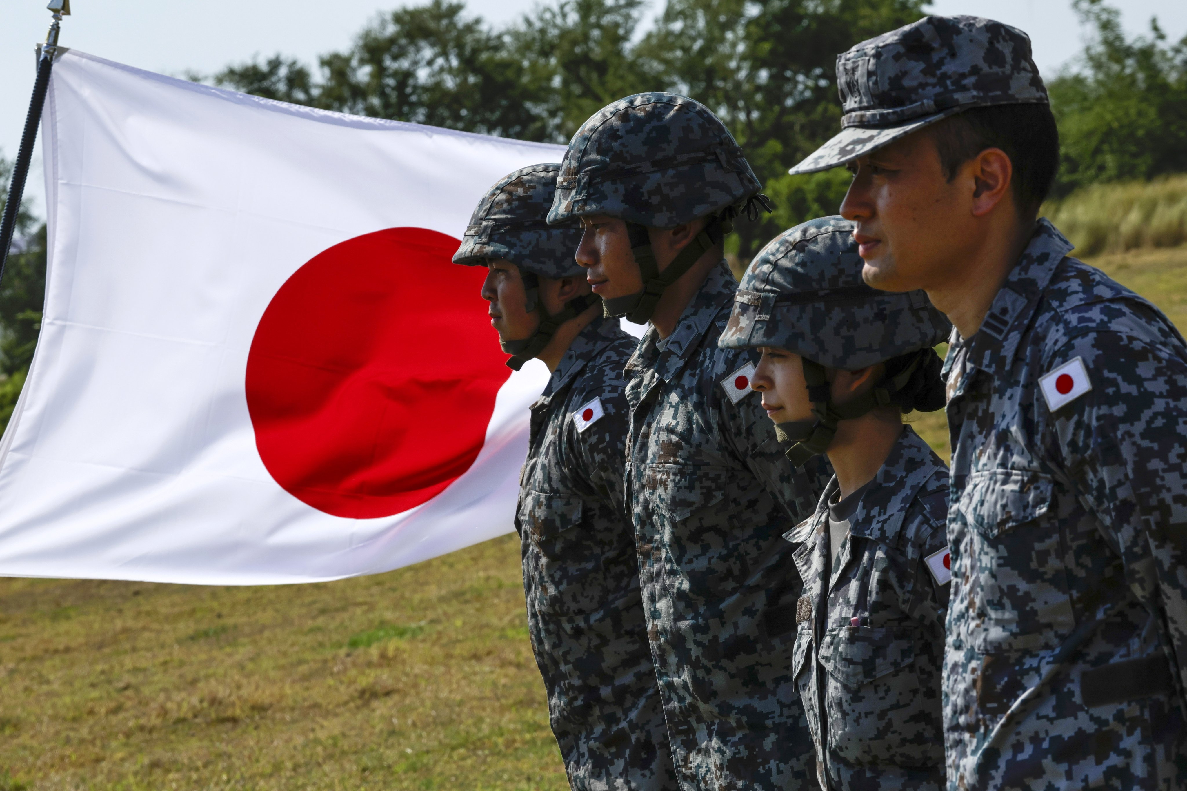 Japanese air force officers stand beside the national flag. Japanese Prime Minister Sanae Takaichi has argued that the country must boost its defence capabilities amid “an increase in the military power of China” and “strengthening cooperation” between Beijing and Moscow. Photo: EPA