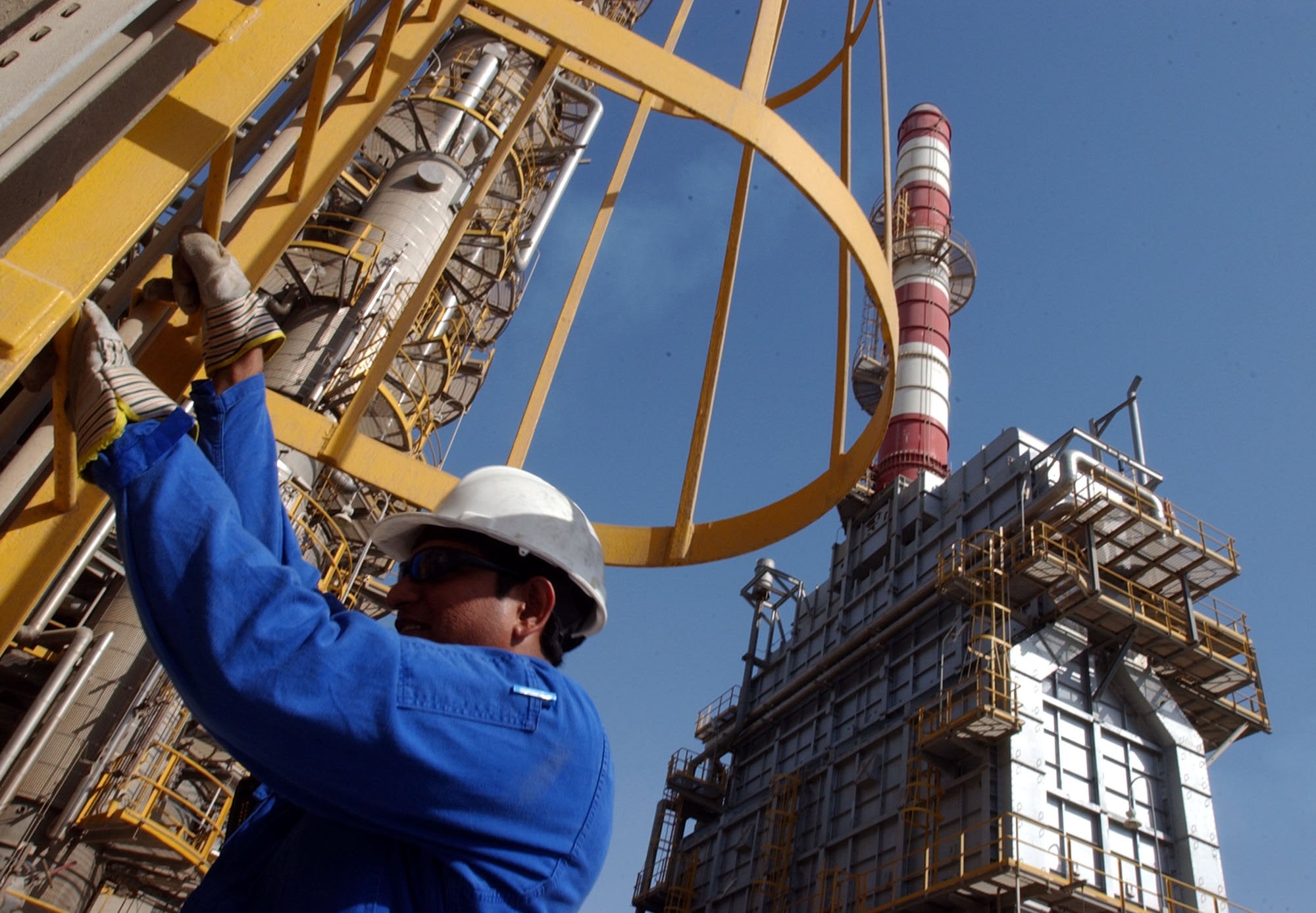 An oil technician climbs down a tower at a refinery in Jebel Ali, UAE. Photo: AP