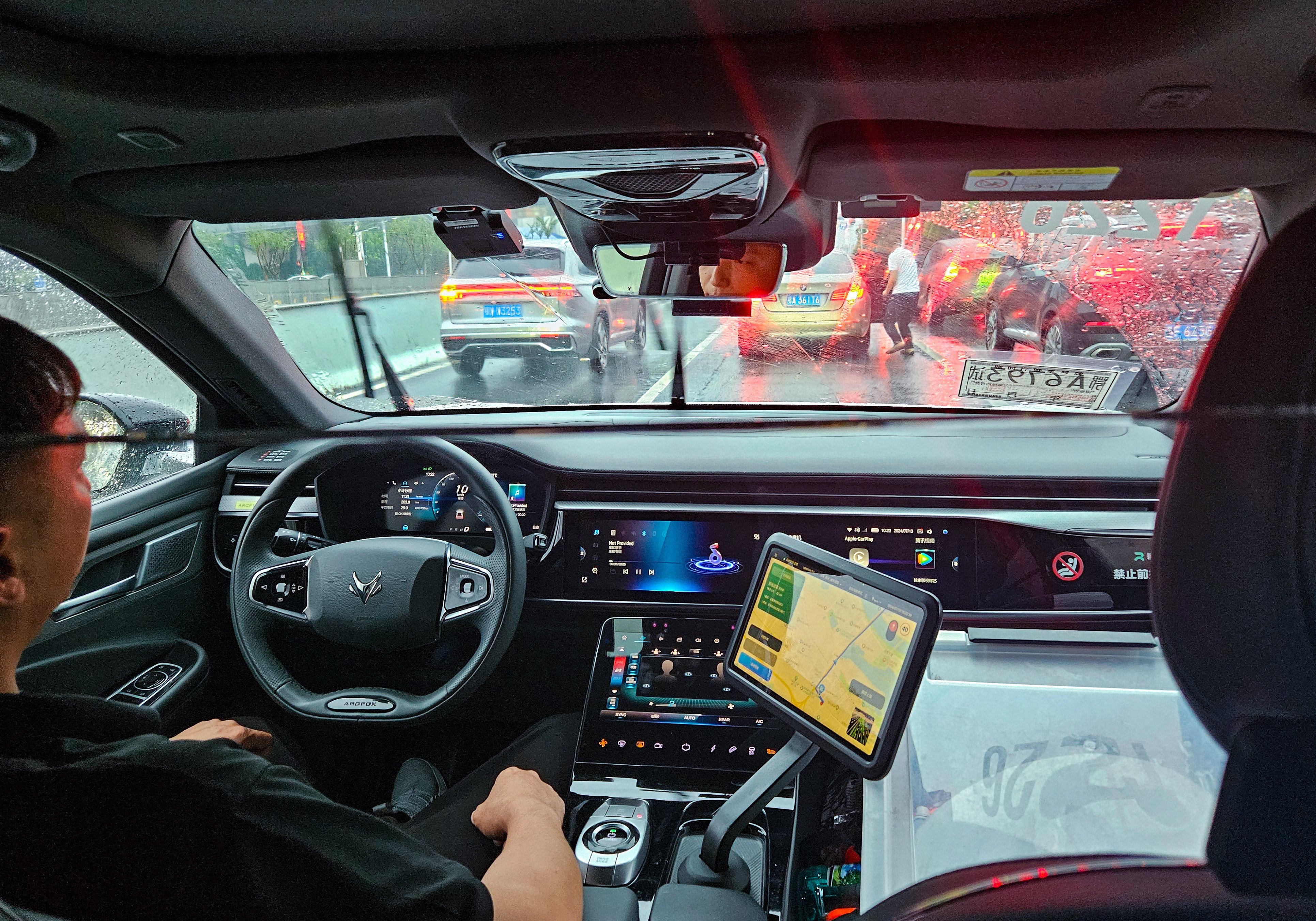 A safety operator sits in the driver’s seat of an Apollo Go robotaxi as the vehicle travels to Wuhan Tianhe International Airport. Photo: Coco Feng