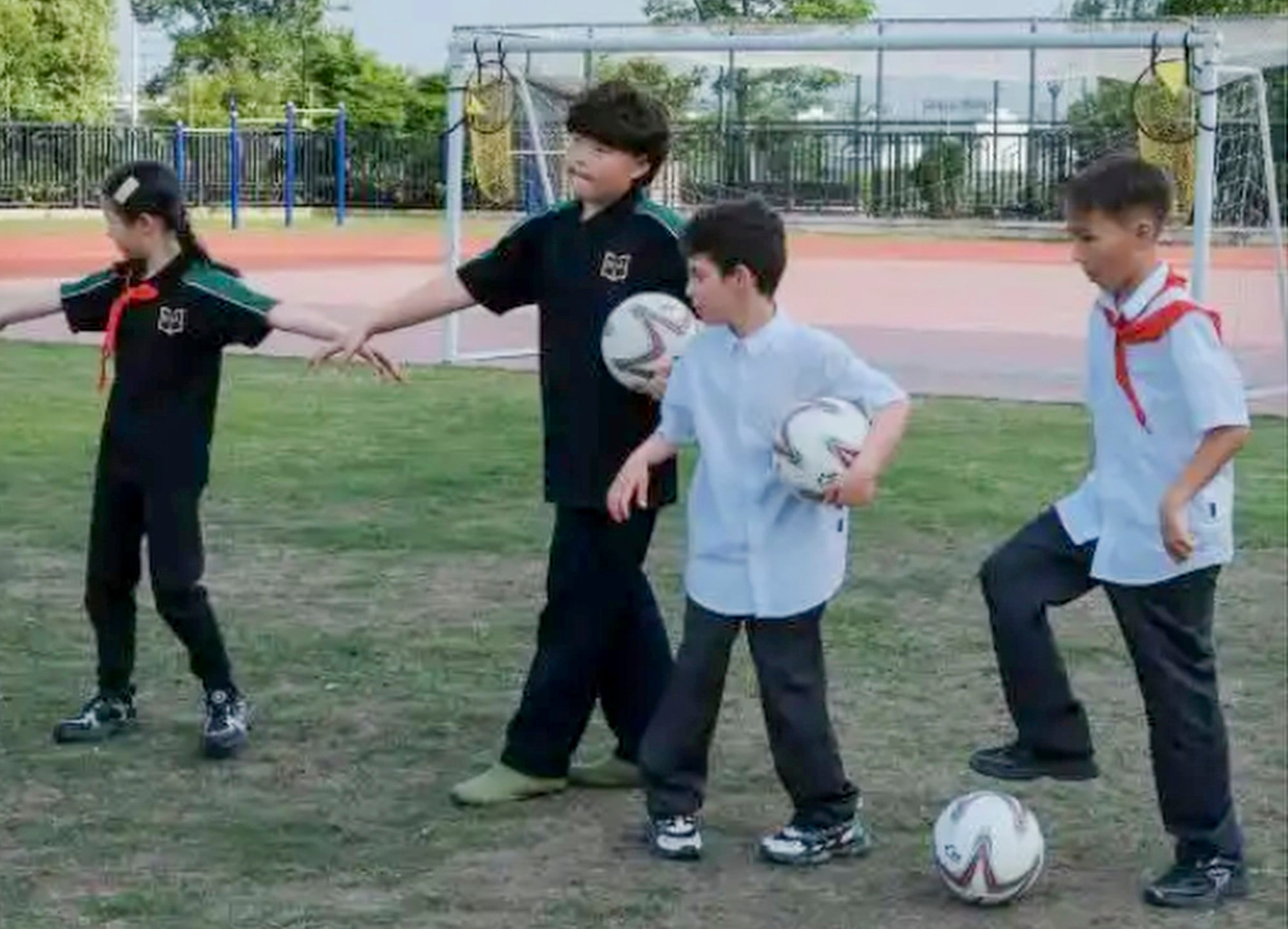 Radin, second left with ball under his arm, plays football with his classmates. Photo: Baidu