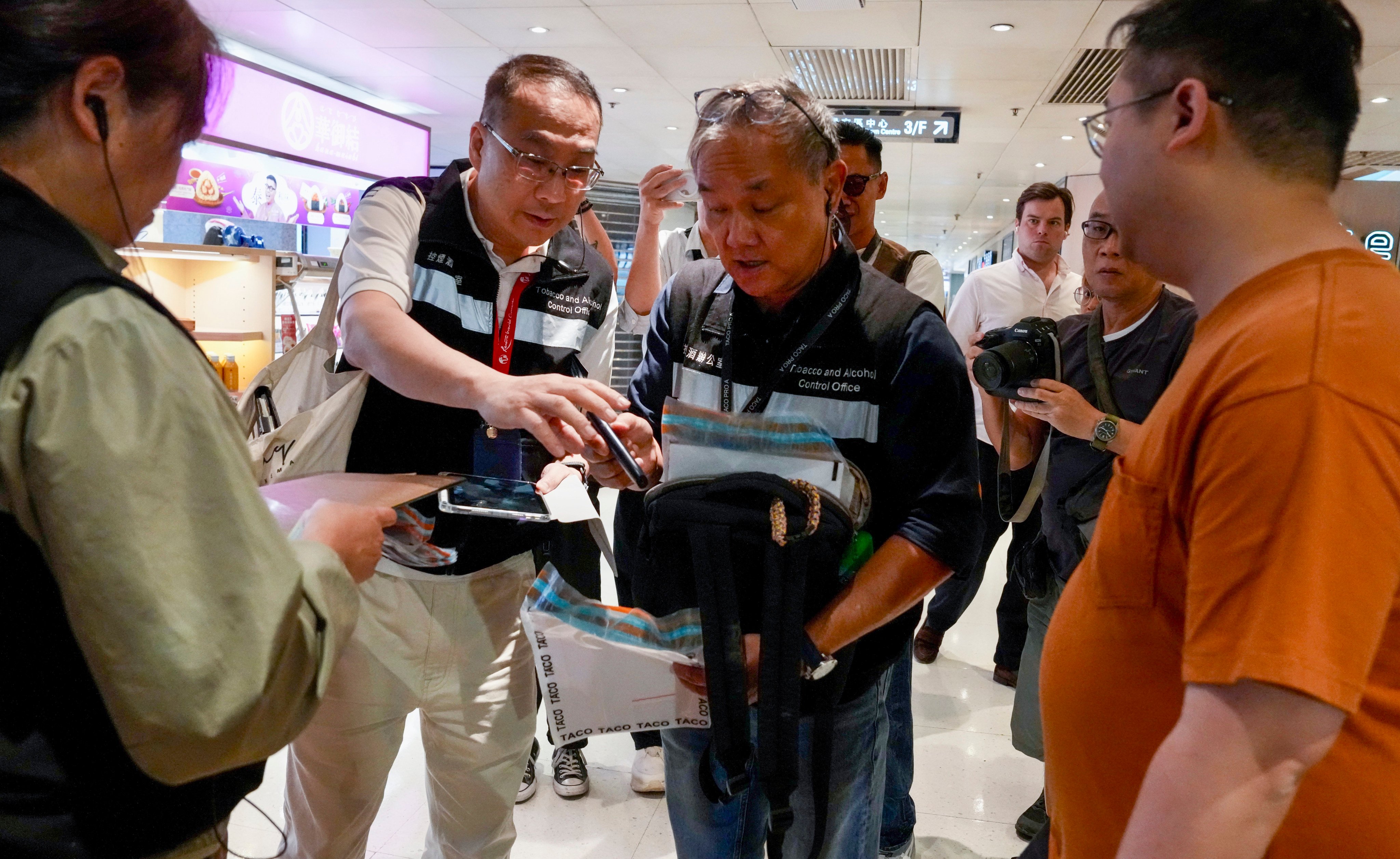A man (in orange t-shirt) has been penalised for vaping in Admiralty. Photo: Jelly Tse