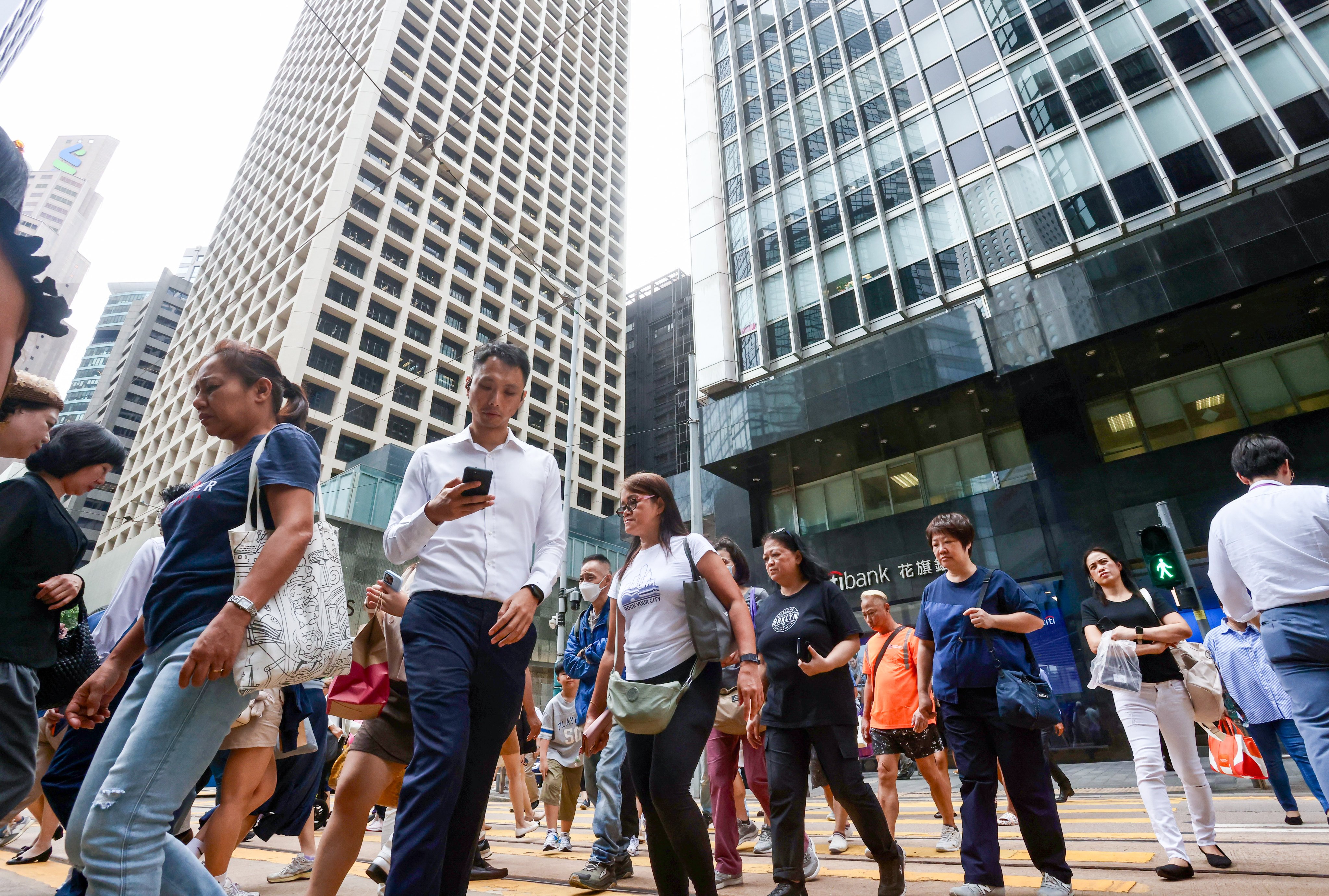 People cross a street in Central on October 20, 2025. Photo: Jonathan Wong