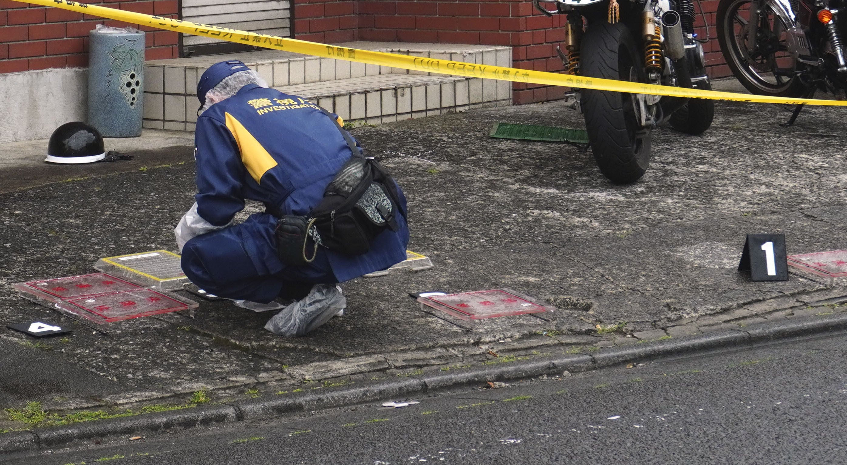 A police officer investigates the scene where a high school student was struck on the head with a hammer by a man in Fussa, western Tokyo, on Wednesday. Photo: Kyodo