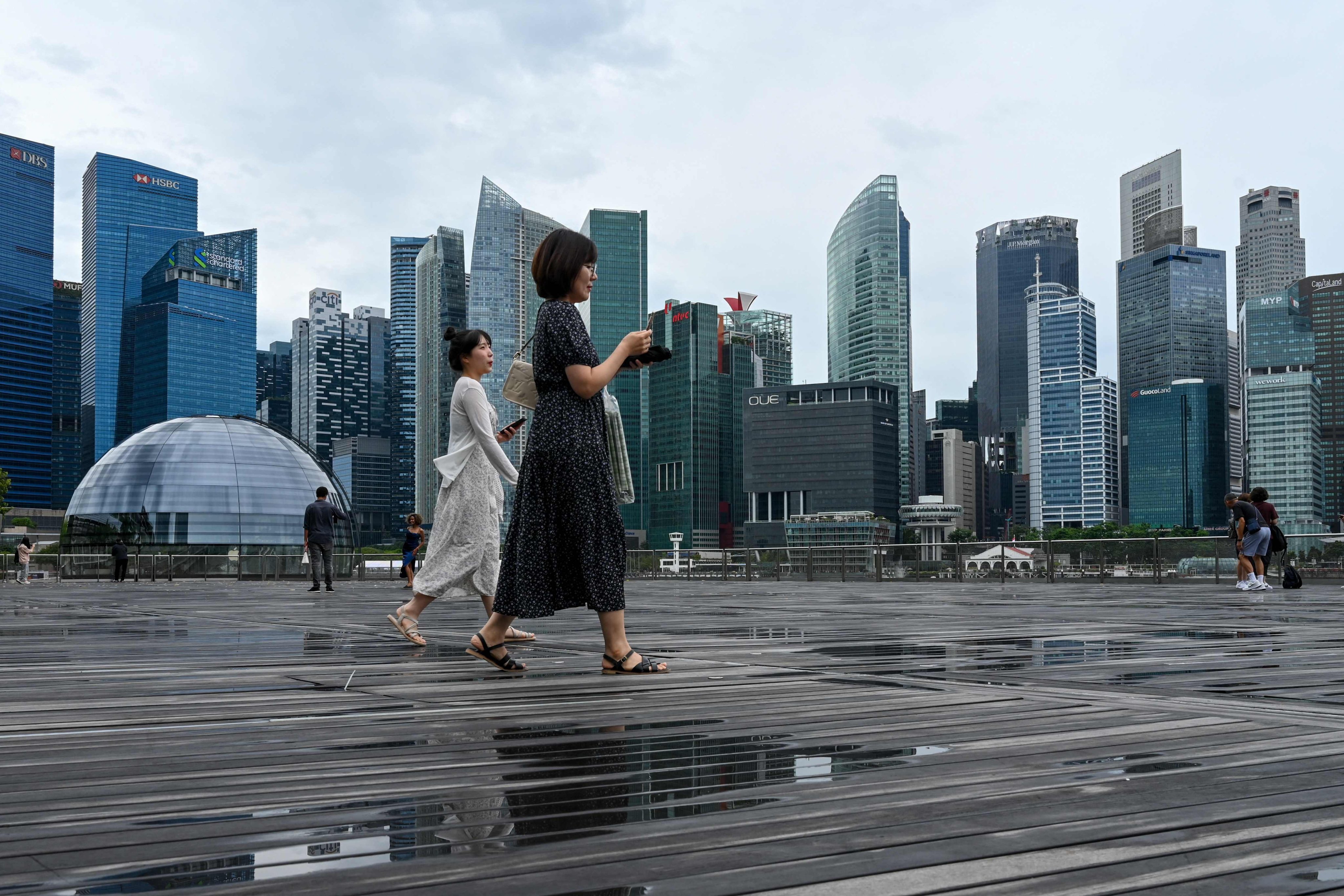 People walk on the boardwalk in front of Singapore’s financial centre. Photo: AFP