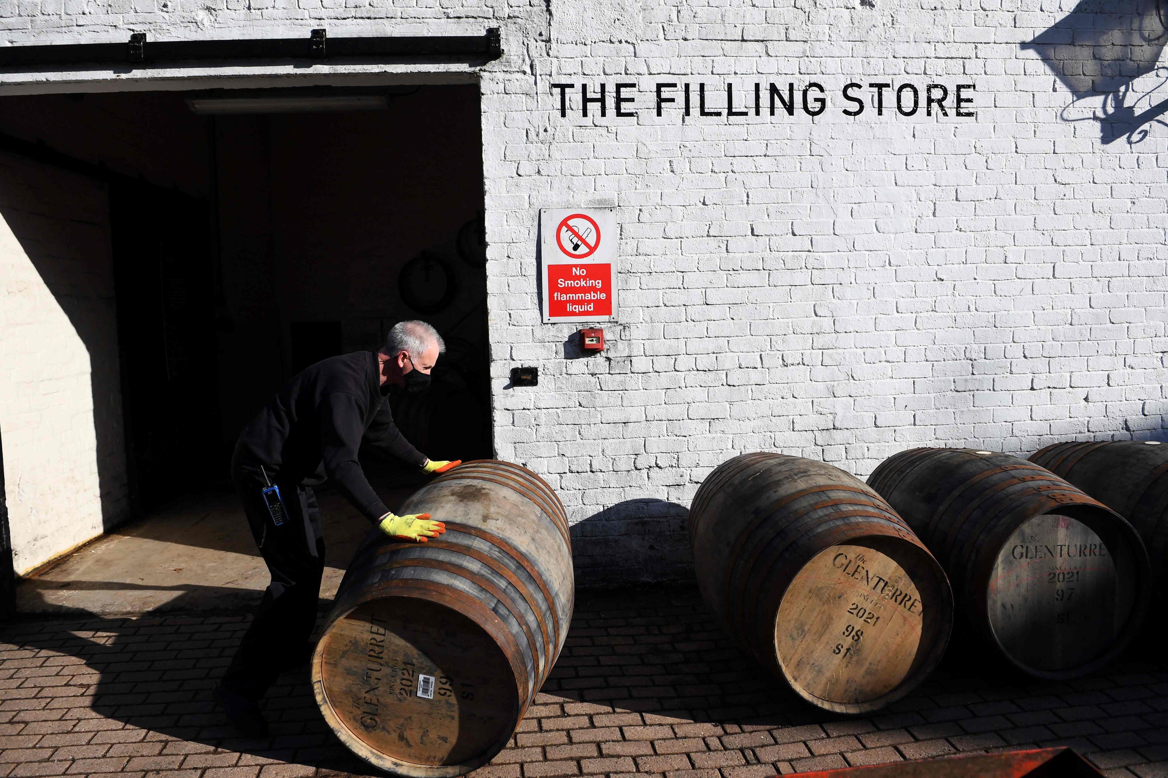 An employee moves a whisky barrel out of the Filling Store at The Glenturret Distillery in Crieff, Scotland, in February 2021. Photo: AFP