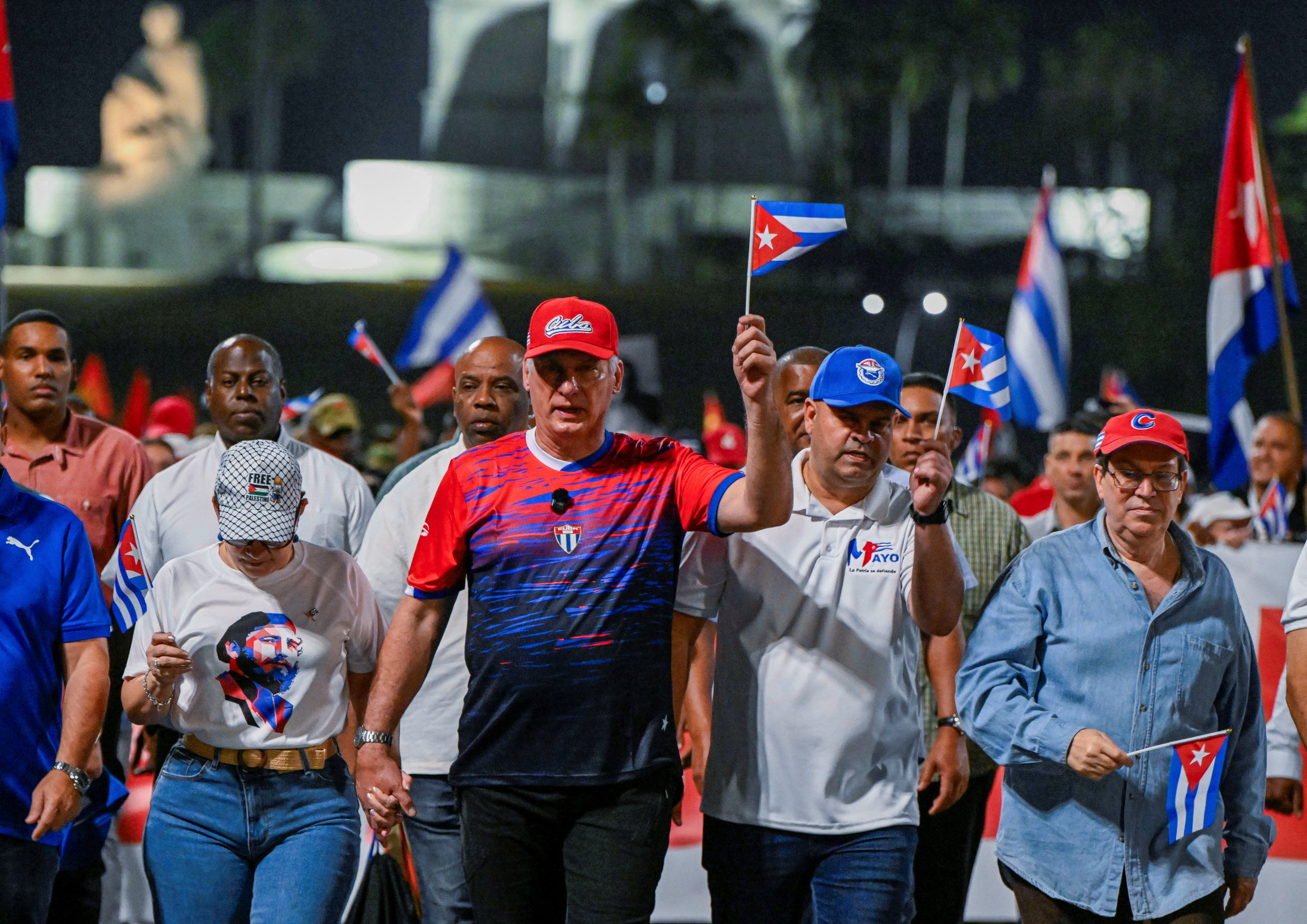 Cuba’s President Miguel Diaz-Canel (centre, in red hat) marches in a May Day parade in Havana, Cuba, on Friday. Photo: pool via Reuters