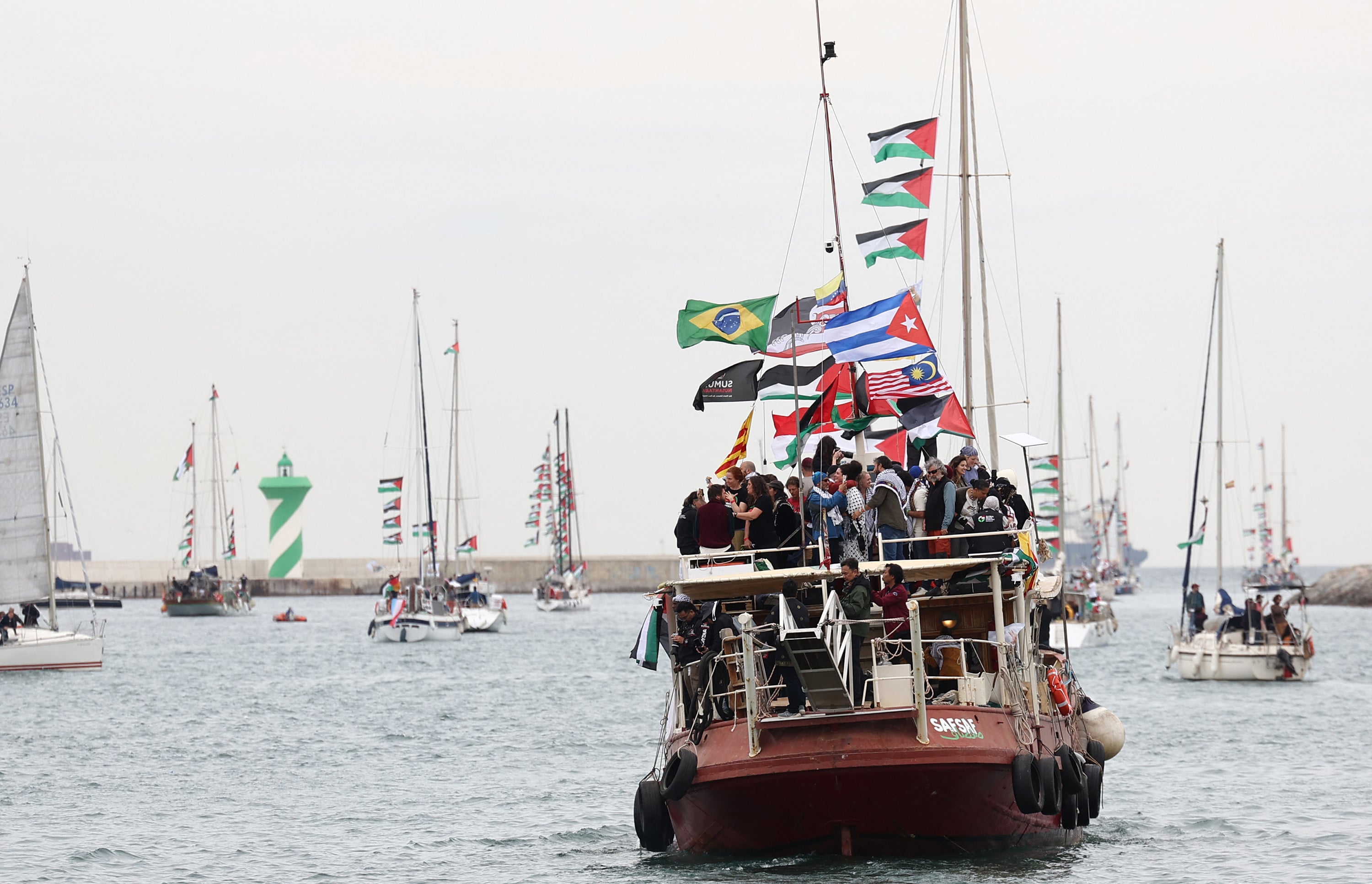 Boats of a new humanitarian flotilla bound for the Gaza Strip make a symbolic departure from Barcelona’s Port Vell on April 12, after the departure of the flotilla was postponed due to bad weather. Photo: AFP