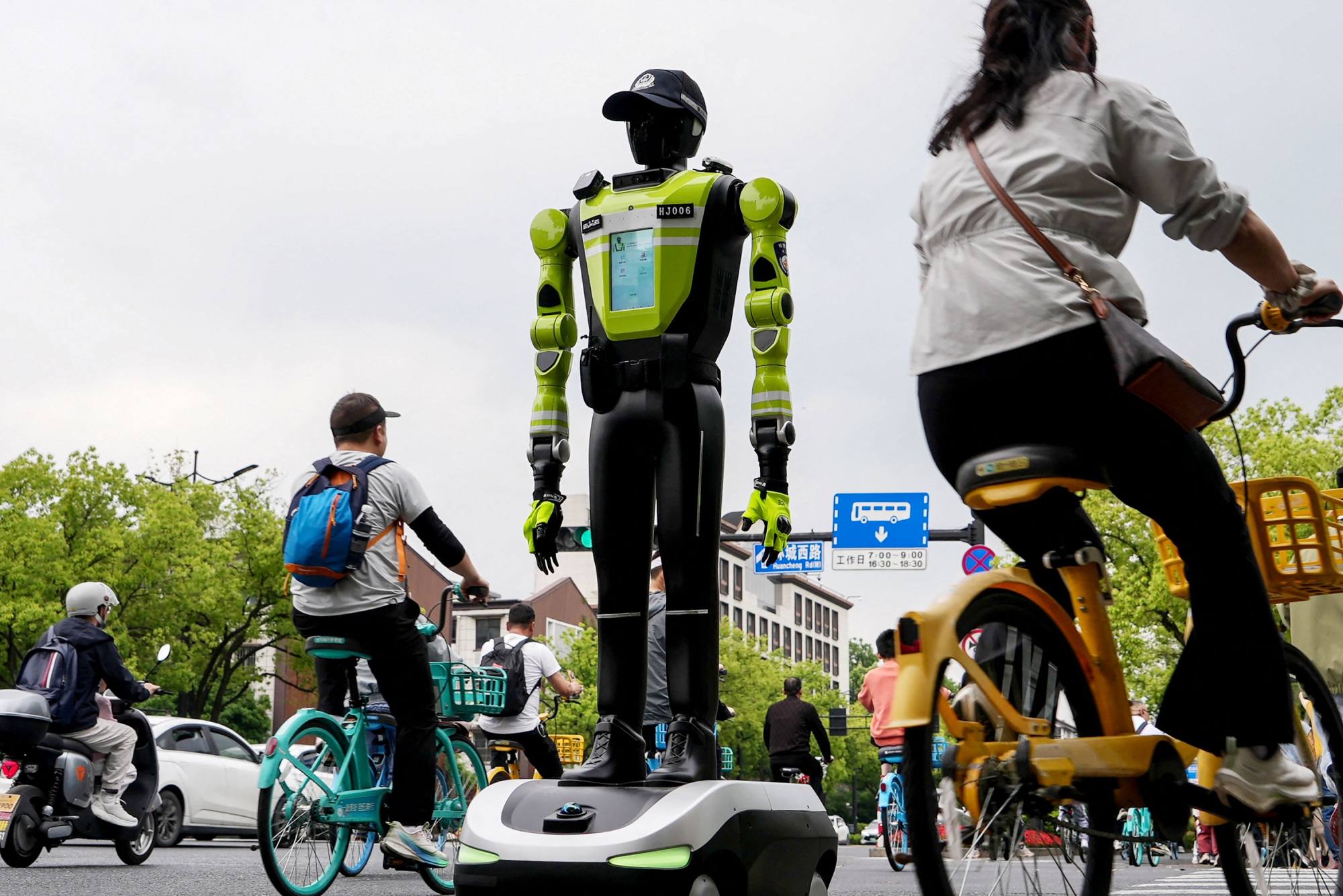 People cycle past a robot police officer in Hangzhou, in China’s eastern Zhejiang province, on May 3. Photo: AFP