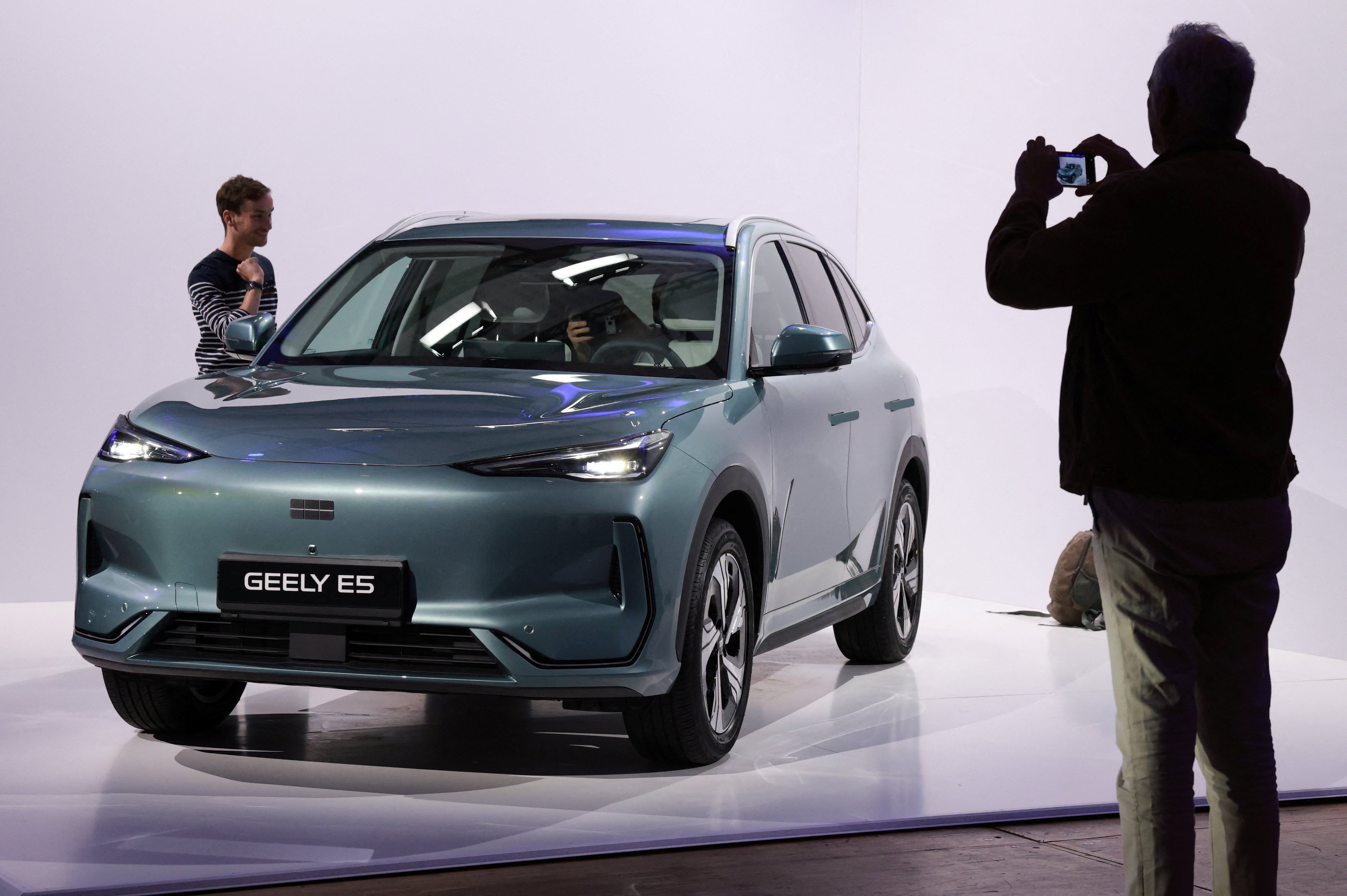 A journalist takes pictures of the Geely E5 electric compact SUV car presented at the launch of Geely Auto France in Paris on April 28. Photo: Reuters