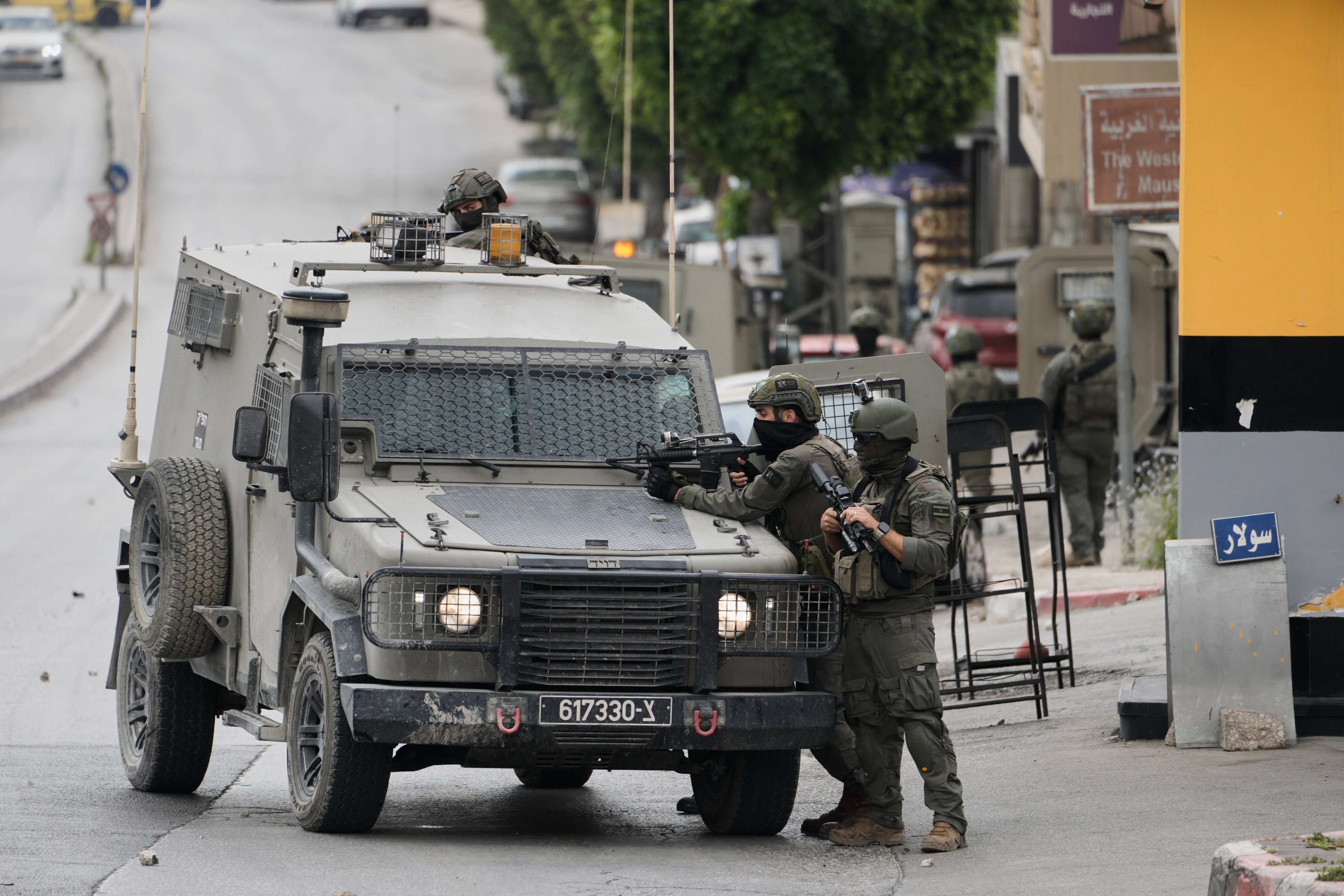 Israeli soldiers take positions during clashes with Palestinians in the West Bank city of Nablus on Sunday. Photo: AP