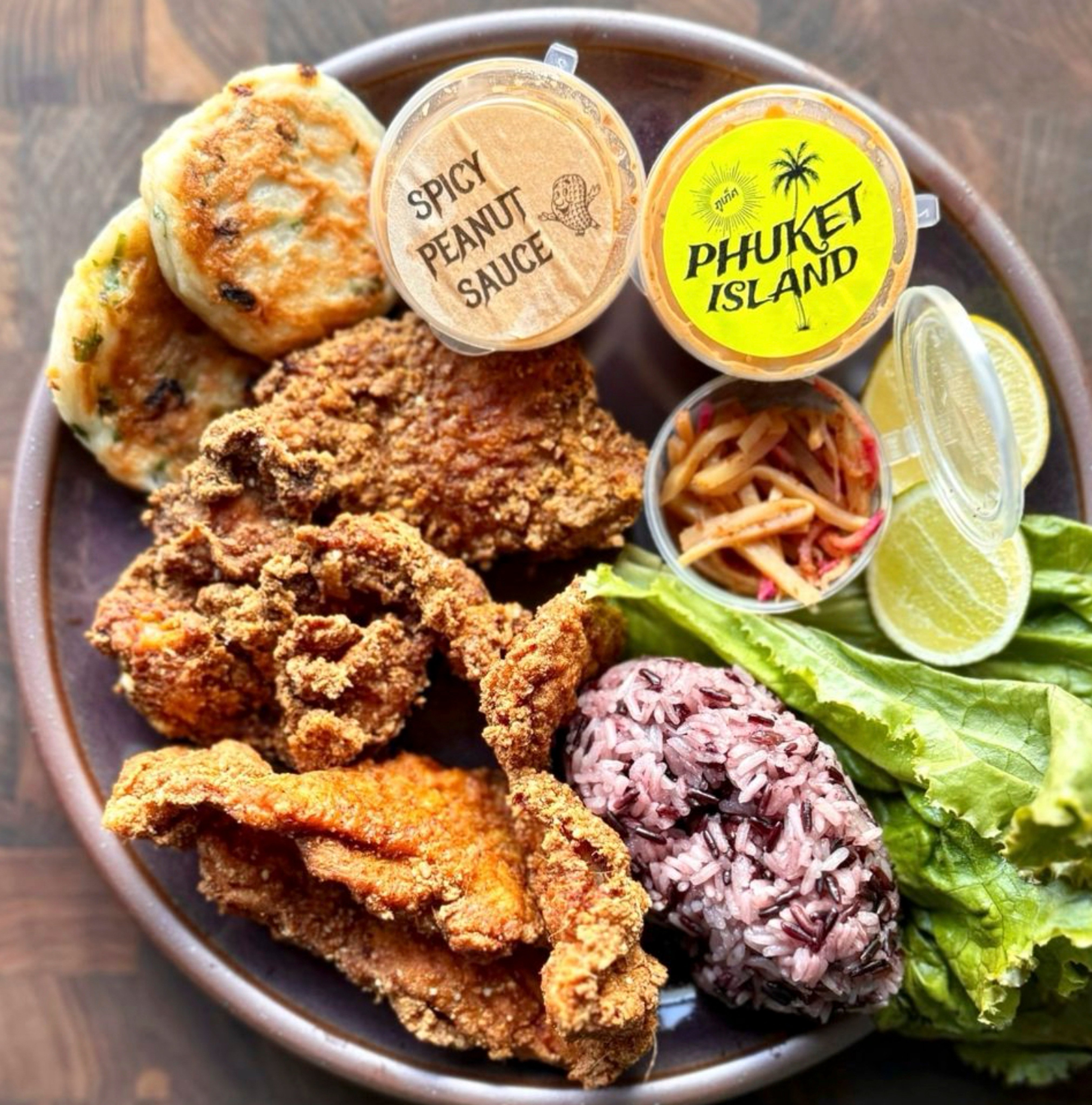 Fried chicken with mommy cakes and sticky rice lettuce wraps at Mommy Pai’s, one of the many restaurants in the US that are looking beyond the classics to put unique twists on Thai dishes.