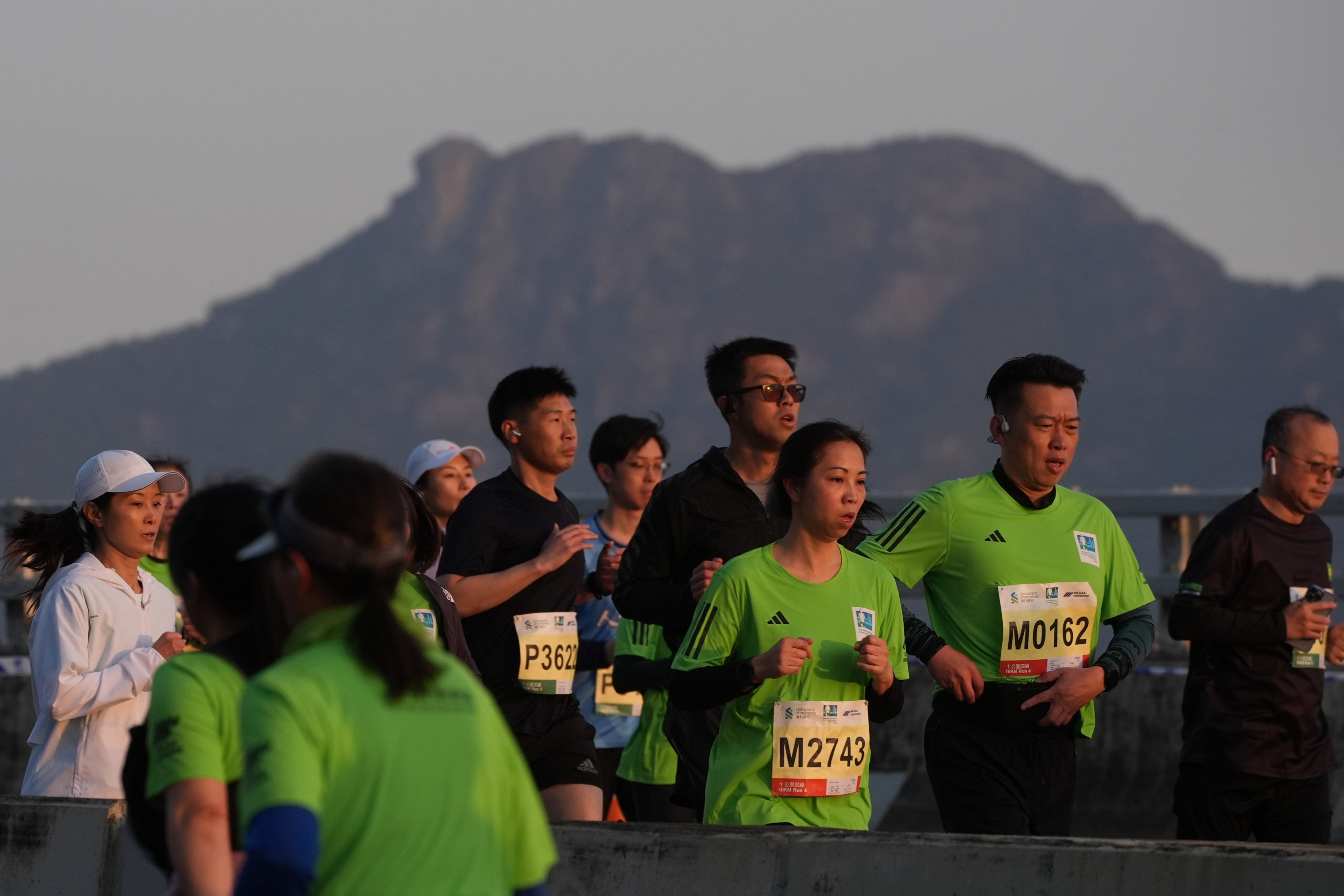 People run along the Island Eastern Corridor in North Point during the Standard Chartered Hong Kong Marathon in 2025, with Lion Rock in the background. Photo: Eugene Lee