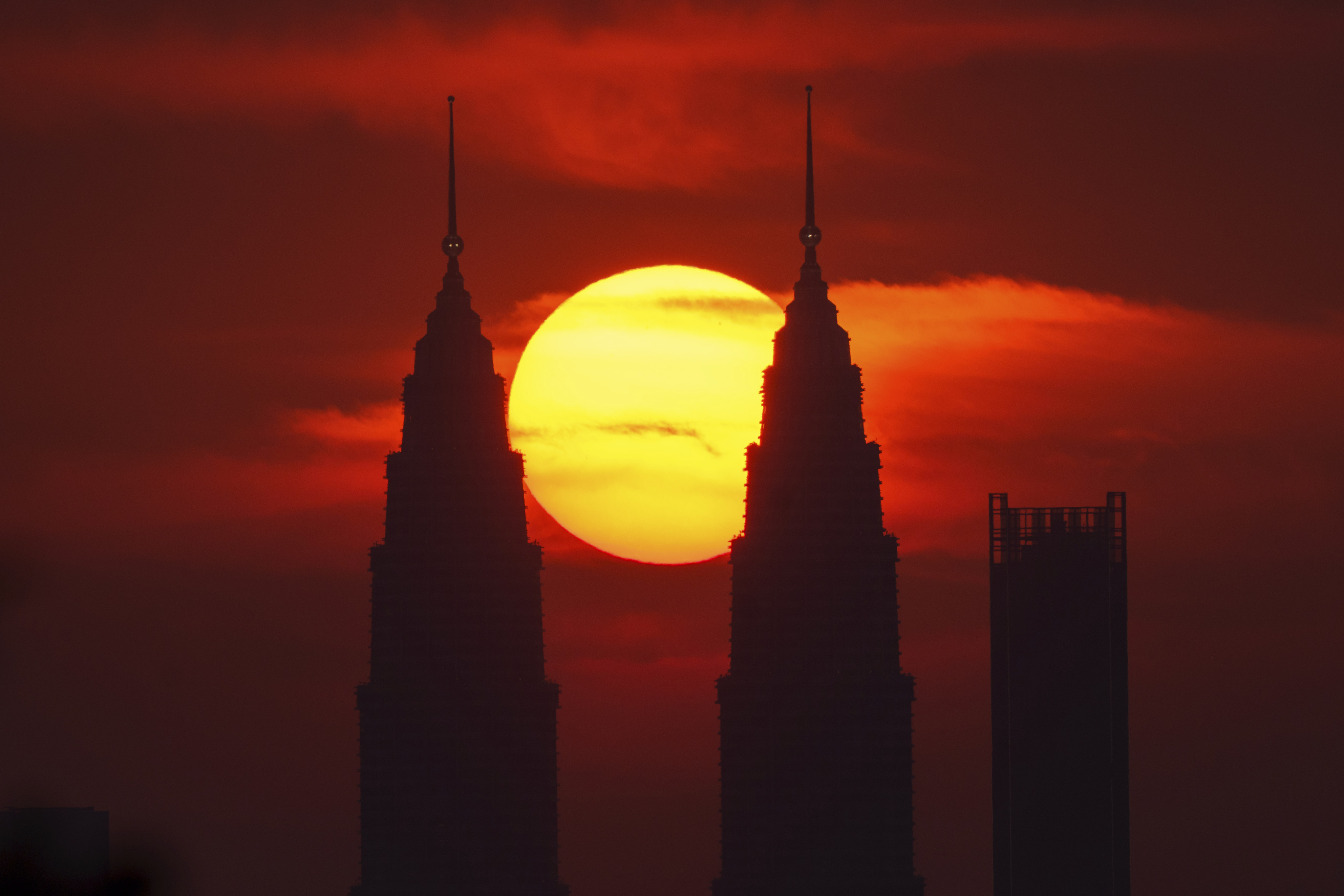 The sun sets behind the Petronas Twin Towers in Kuala Lumpur. Temperatures in Malaysia have soared to the mid-30s degrees Celsius. Photo: AP
