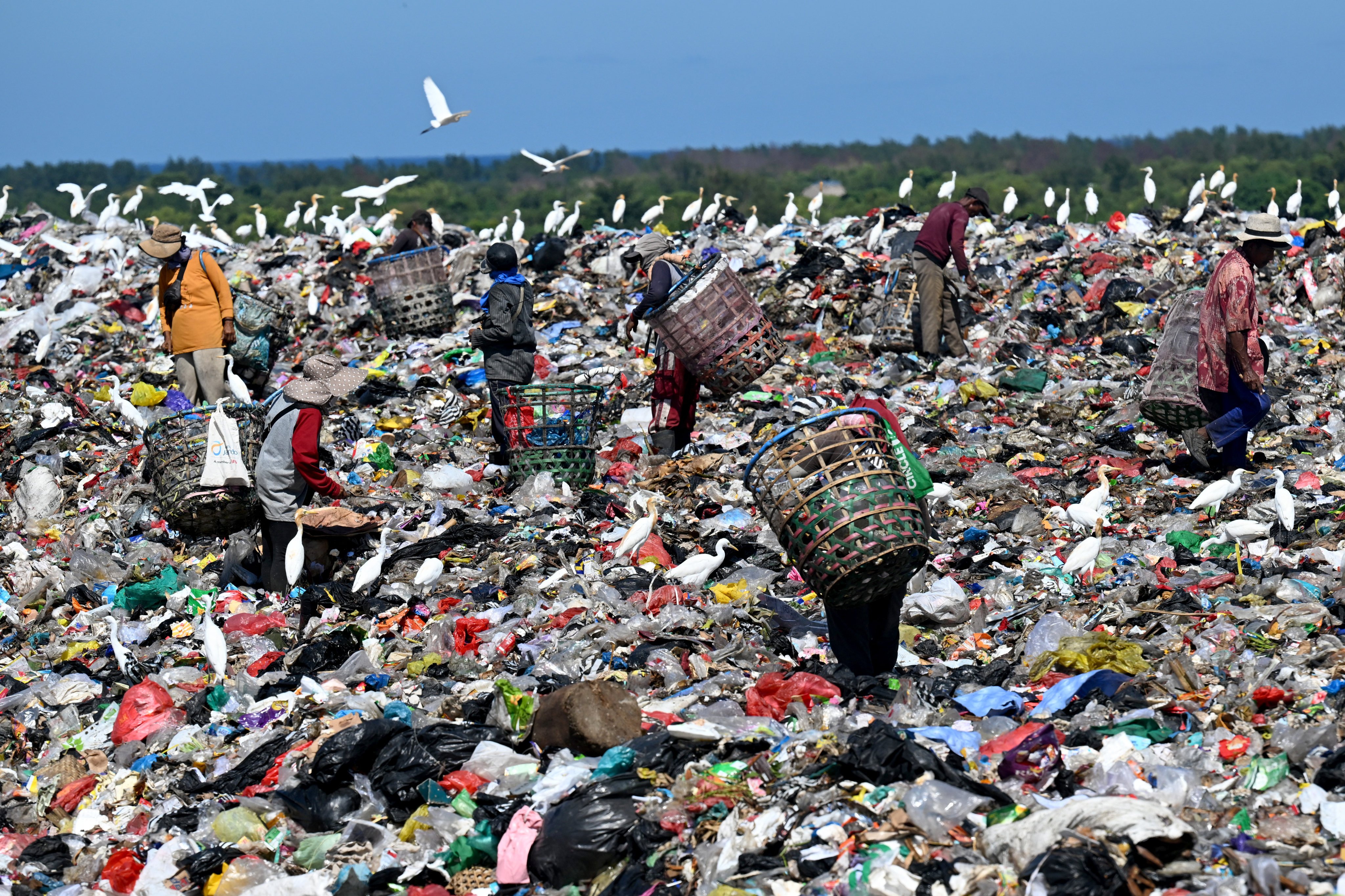 People collect waste at the Suwung landfill in Denpasar, on Indonesia’s resort island of Bali on April 17, 2026. (Photo by SONNY TUMBELAKA / AFP)