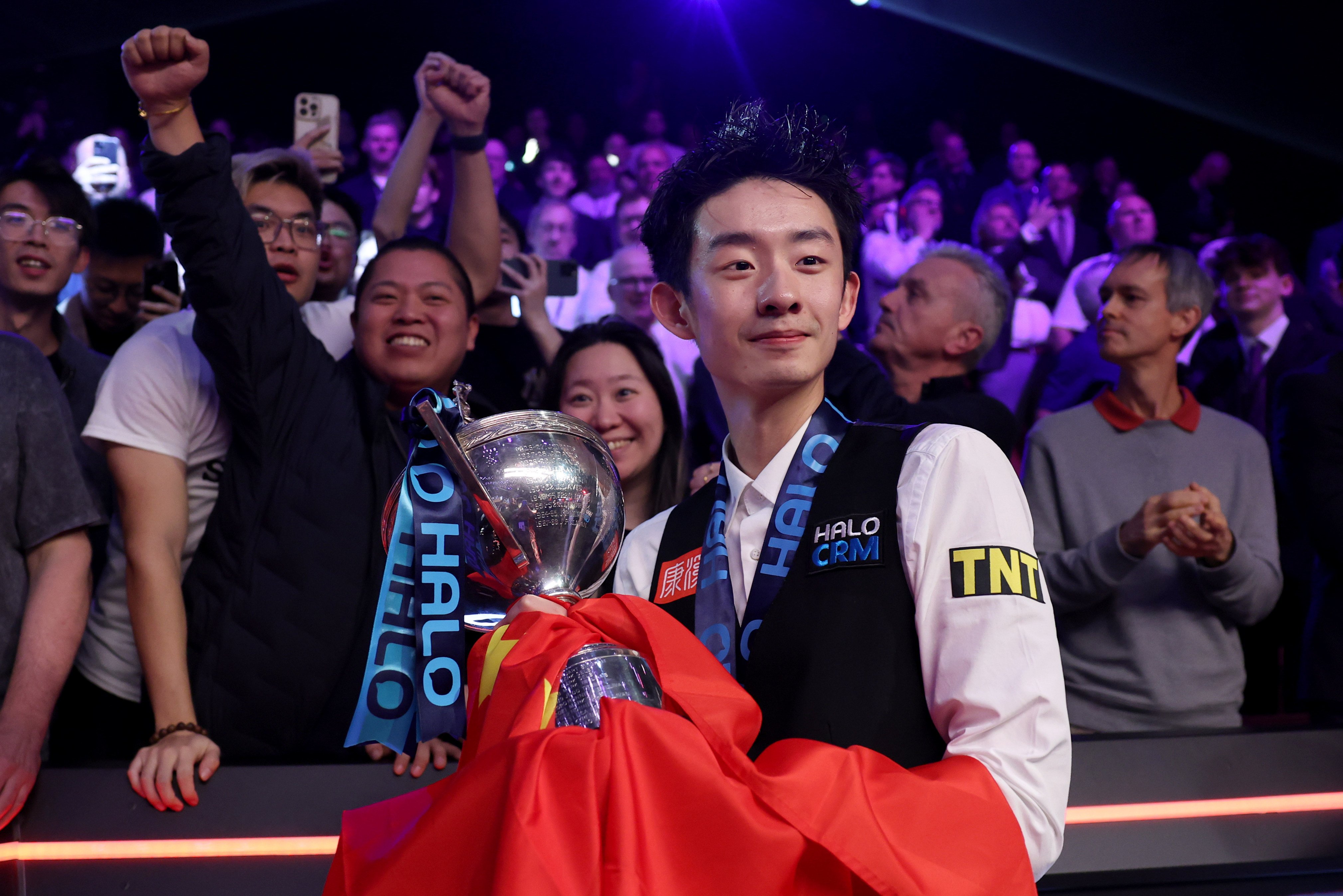 Wu Yize with the trophy and his fans after defeating England’s Shaun Murphy in Sheffield on Monday. Photo: Xinhua