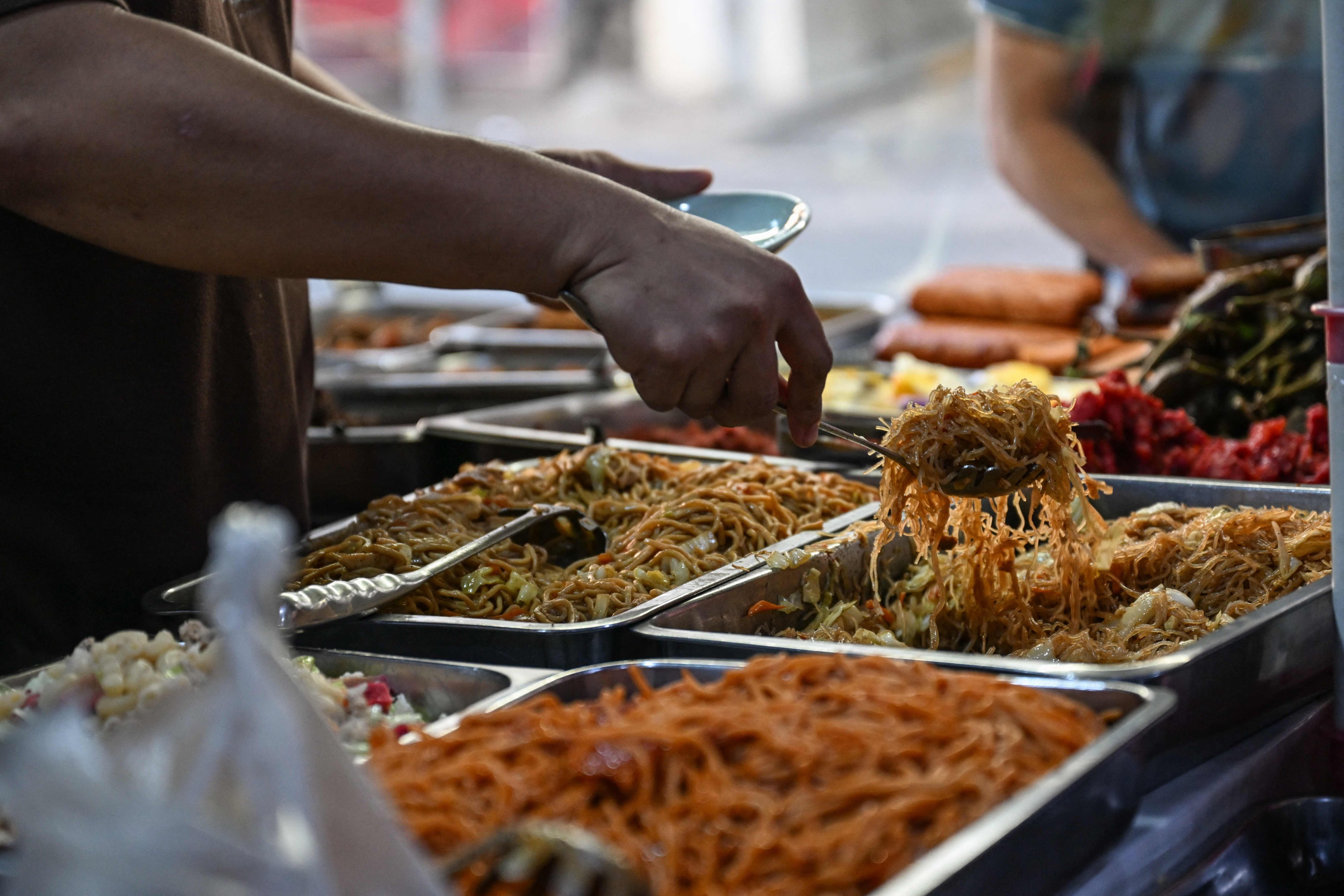 A man scops up food at a canteen in Manila on April 7. Photo: AFP