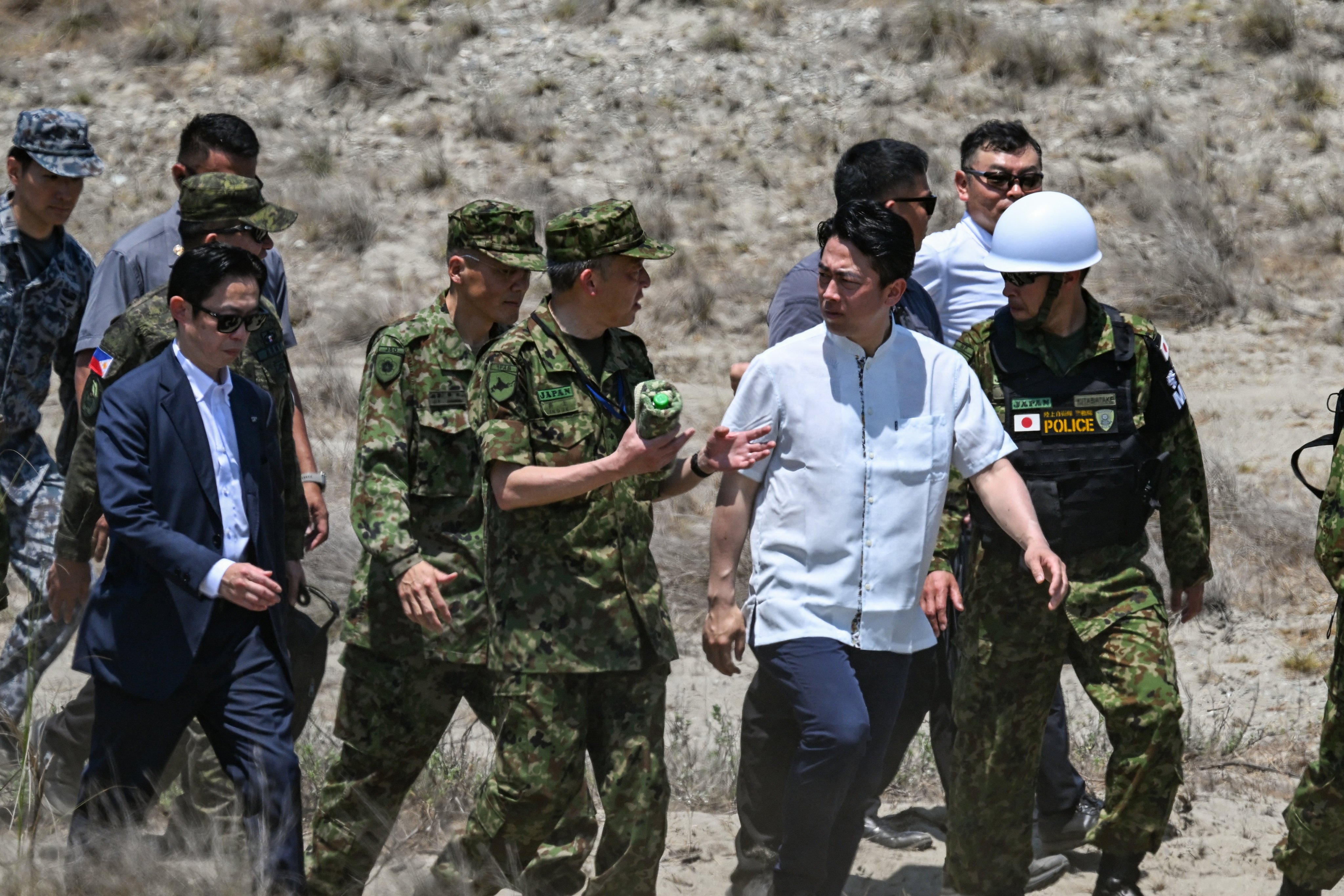 Japans Defence Minister Shinjiro Koizumi (2nd-R) walks along with soldiers during the maritime strike of Balikatan exercise between US, Australian, Filipino and Japanese troops in Paoay, Ilocos Norte on May 6, 2026. (Photo by Jam STA ROSA / AFP)