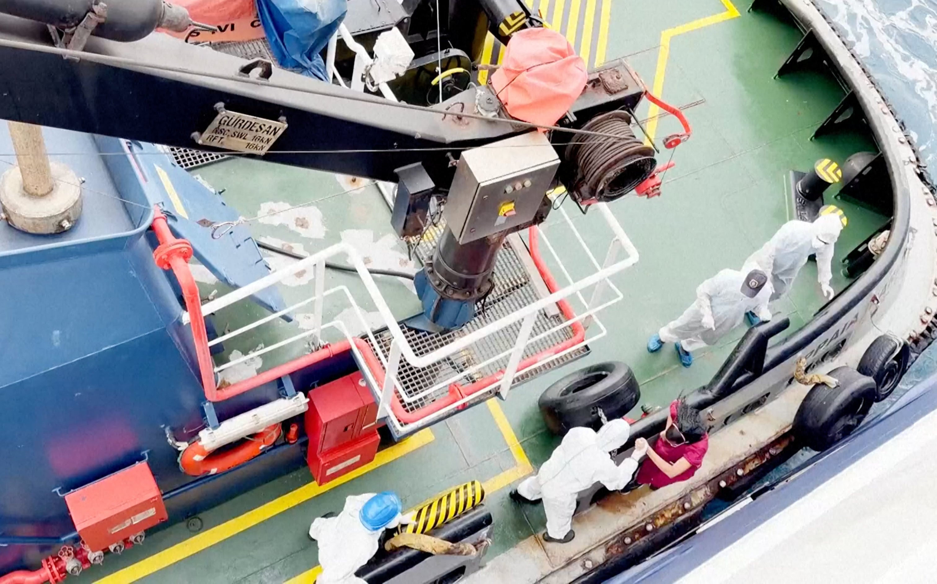 Health workers get off the MV Hondius as it remains off Cabo Verde on Monday. Photo: Qasem Elhato via AP
