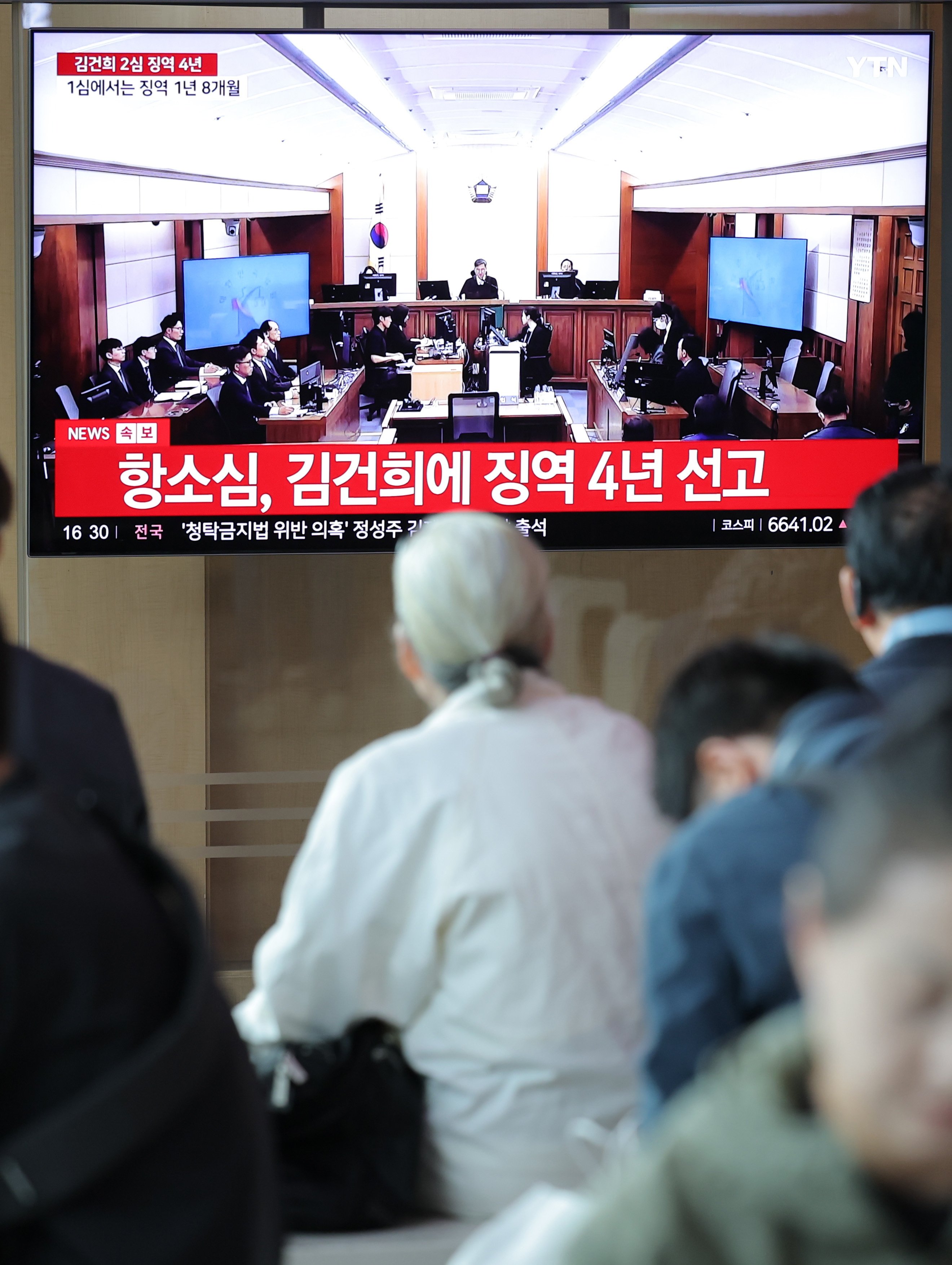 People watch a live TV broadcast of Kim Keon-hee’s appeals trial, presided over by Shin Jong-oh, at Seoul Station on April 28. Photo: Yonhap/EPA