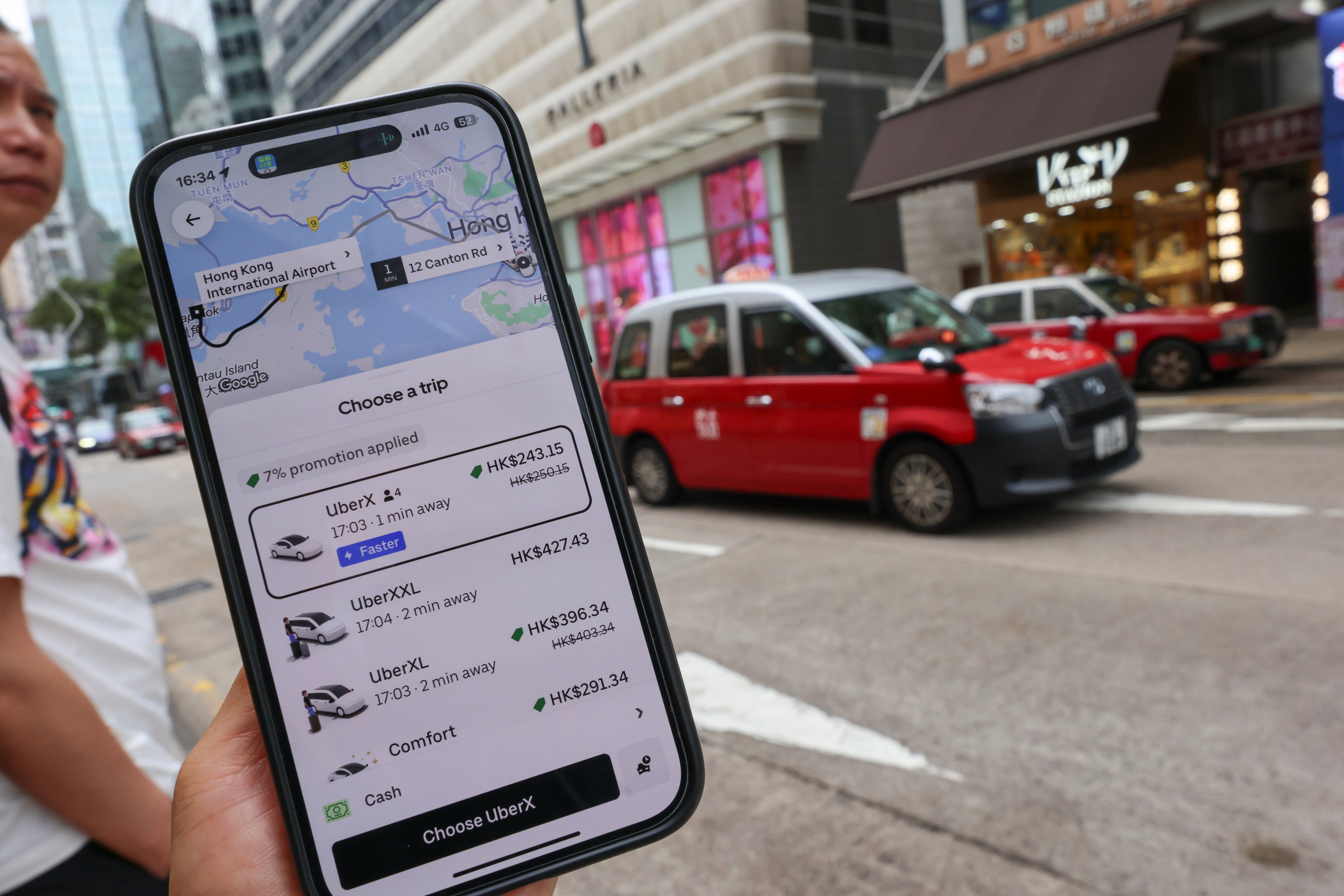 The Uber app is seen opened on a mobile phone as a taxi drives past in Tsim Sha Tsui on May 16, 2025. Photo: Jelly Tse