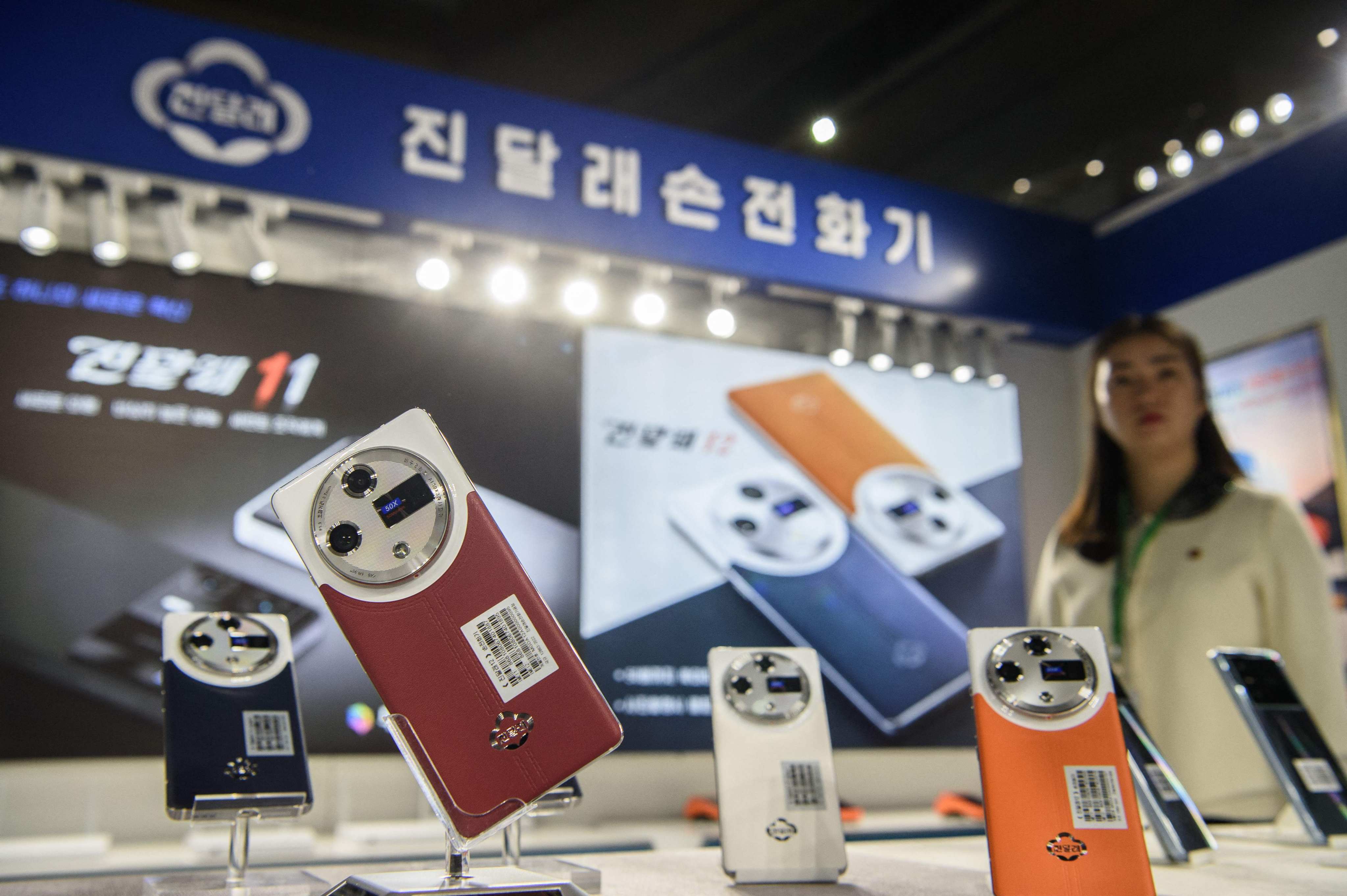 Domestically produced Jindallae mobile phones are displayed during the  Pyongyang Spring International Trade Fair on Monday. Photo: AFP