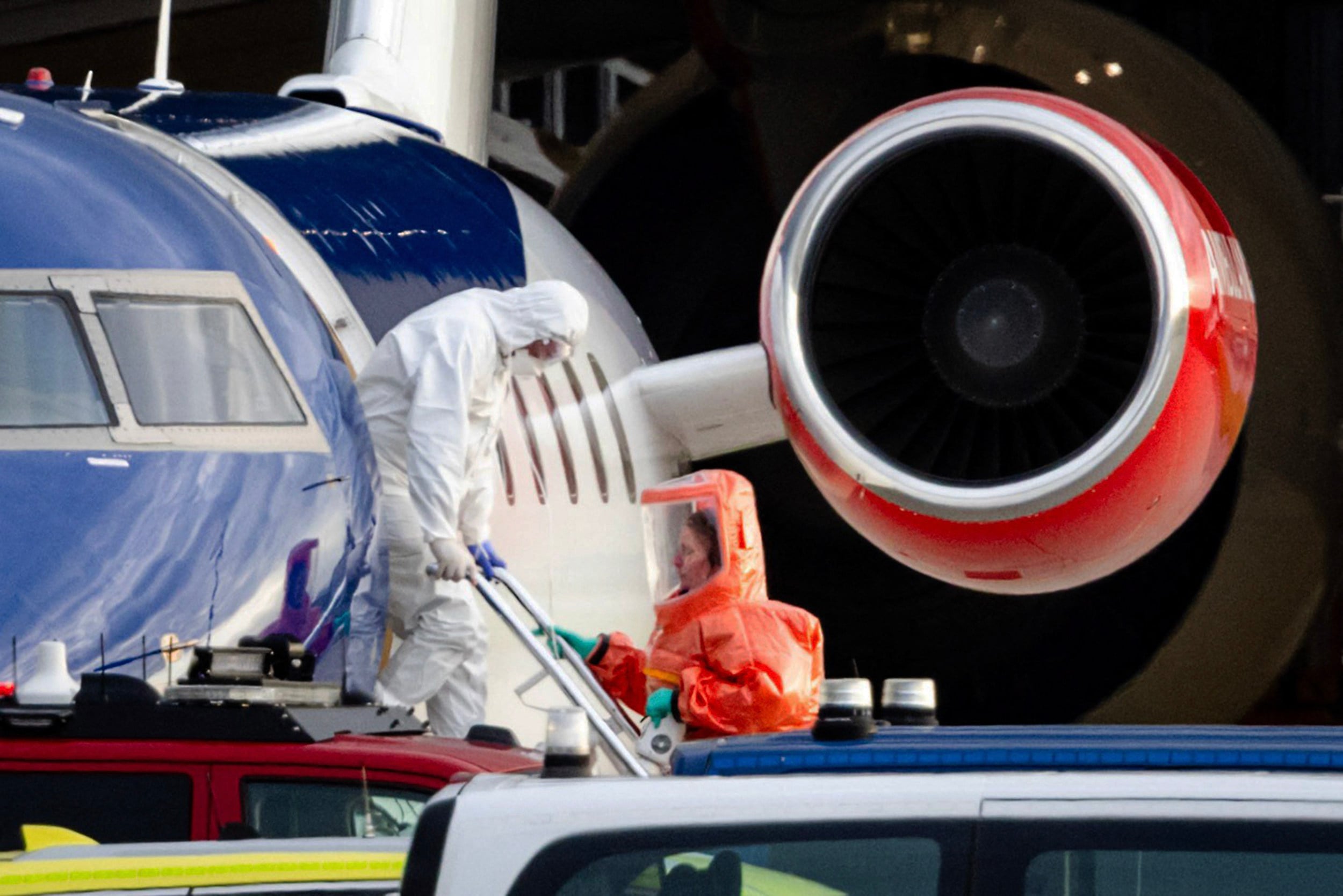 A person in a white hazmat suit disembarks a medical aircraft in Amsterdam on Wednesday. Photo: ANP via AFP