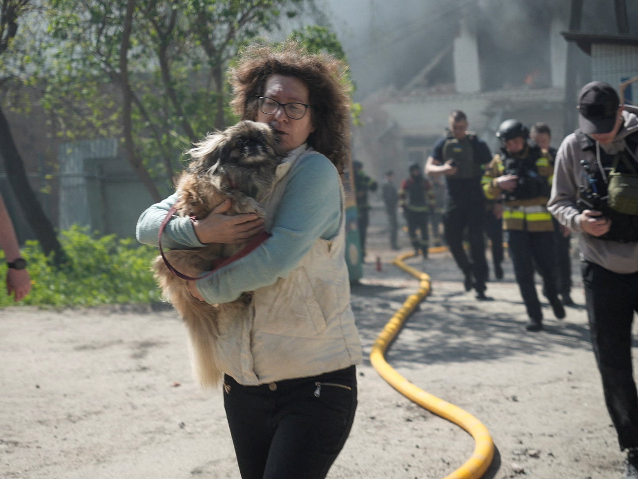 A woman flees with a dog during an air raid in Sumy, Ukraine, on Wednesday. Photo: Reuters