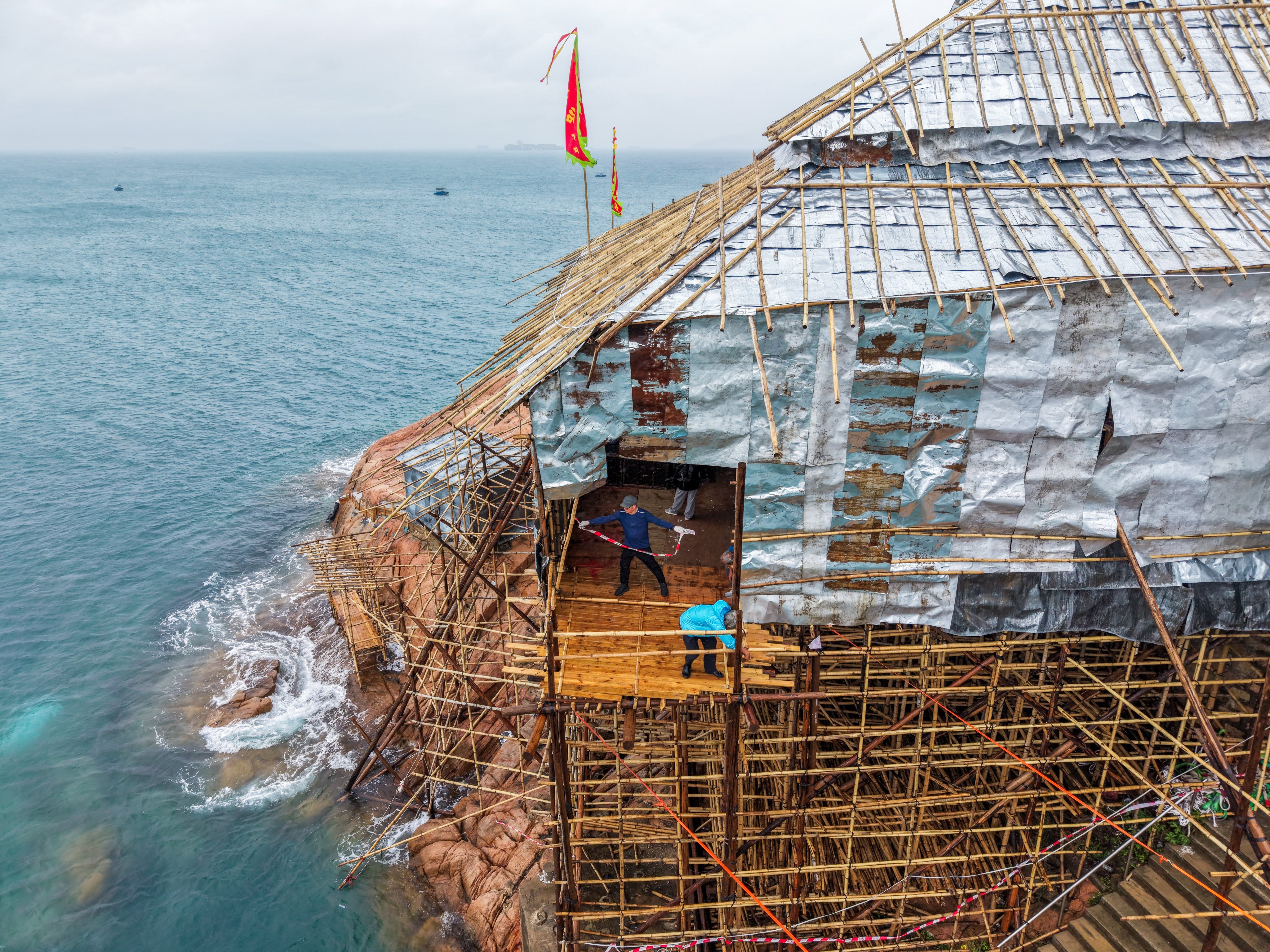 Workers make final preparations at the temporary bamboo theatre on Po Toi Island ahead of the Tin Hau Festival. 05MAY26. SCMP / Eugene Lee