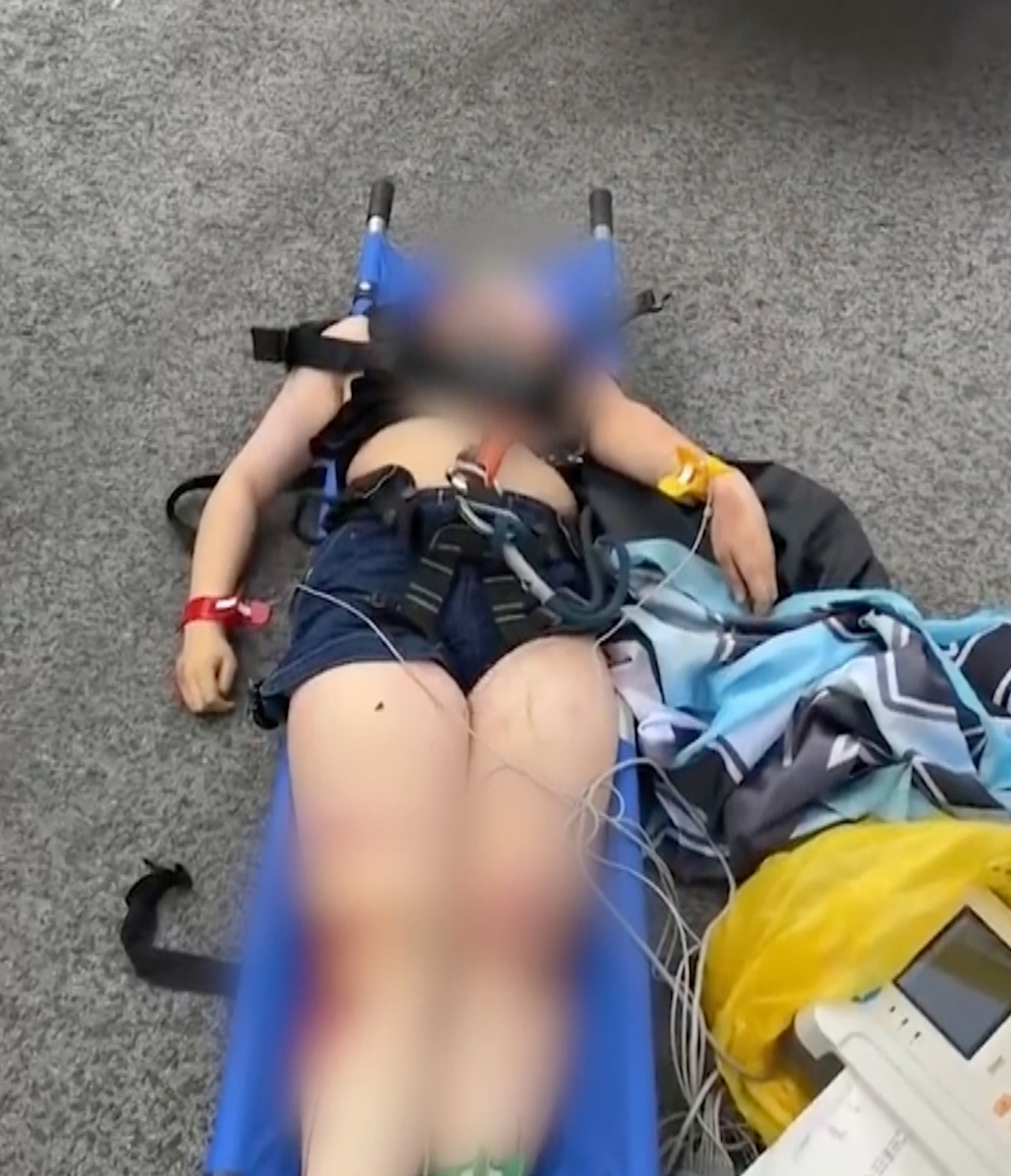 The young woman lies on a stretcher awaiting emergency medical treatment. Photo: Handout