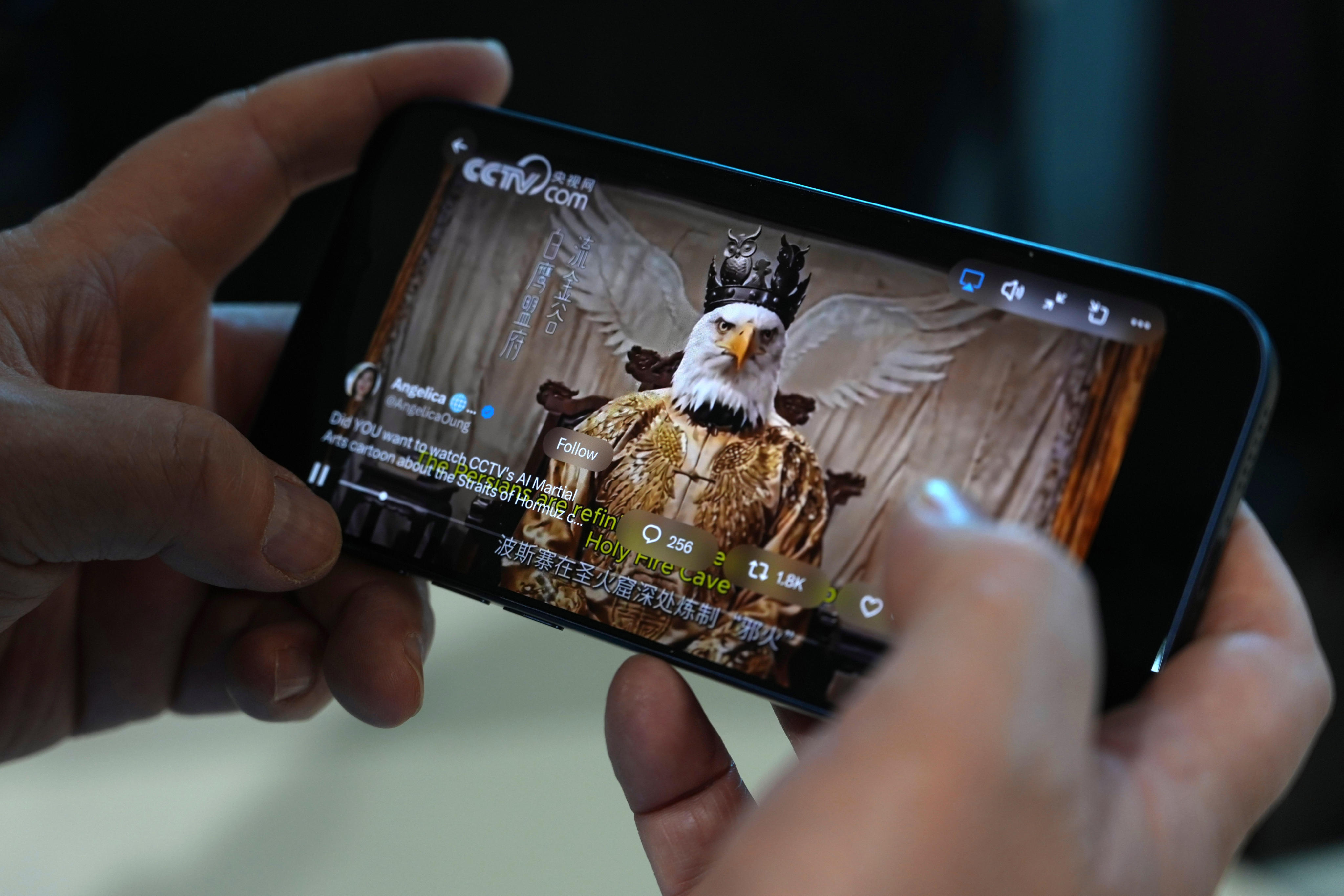An AI-made video by Chinese state media mocking the United States is seen on a mobile phone in Beijing on April 6. China has been engaged in an intense war of narratives with the US in recent years. Photo: AP