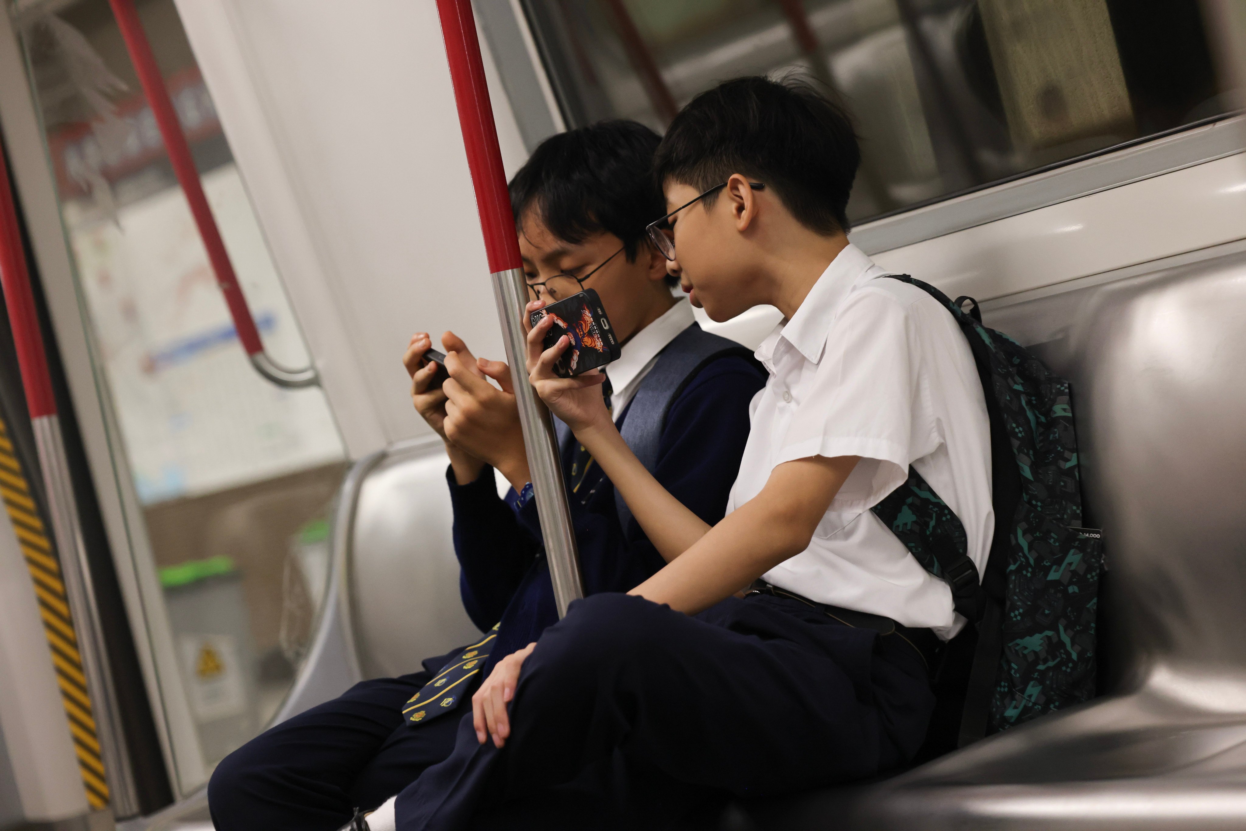 Youths use mobile phones on the train on June 27, 2025. Photo: Jelly Tse
