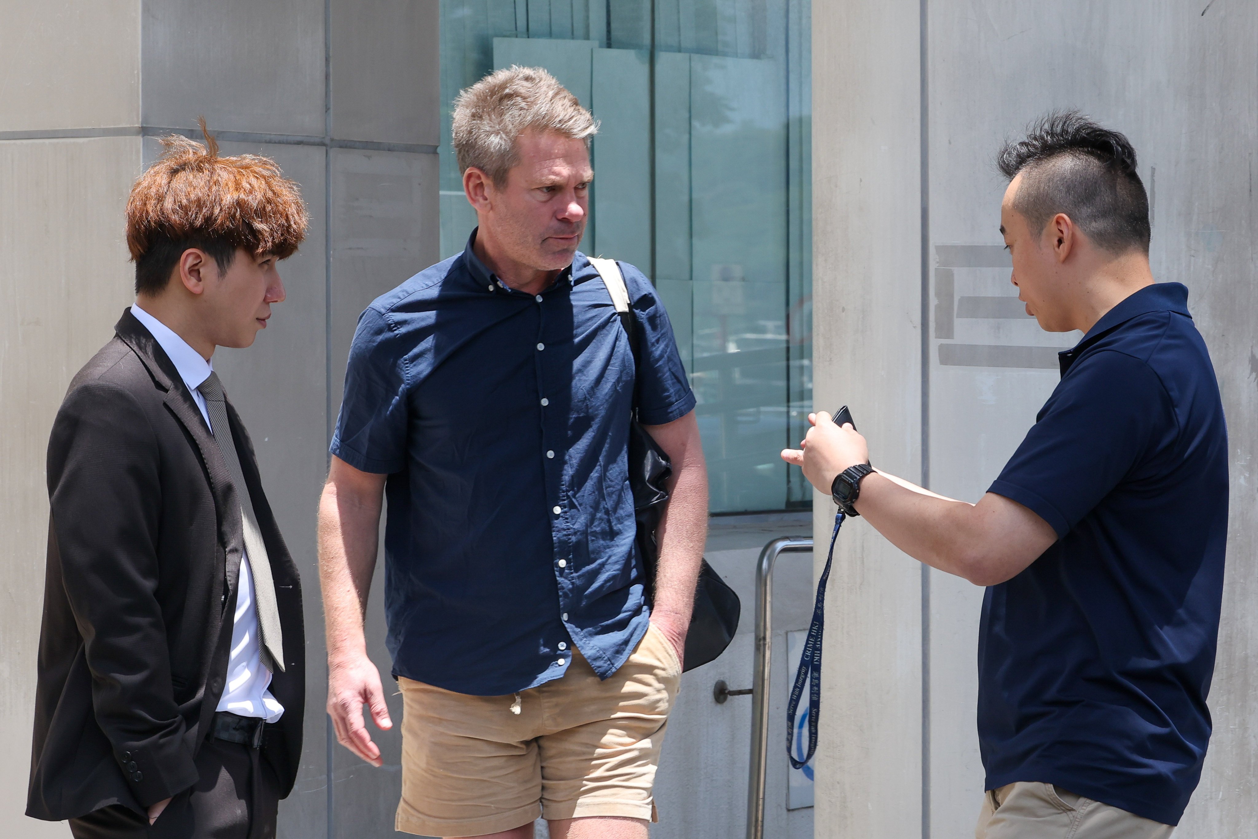 Samuel Monkivitch (centre) was approached by men believed to be plain-clothes police officers after leaving Eastern Court on Thursday. Photo: Edmond So