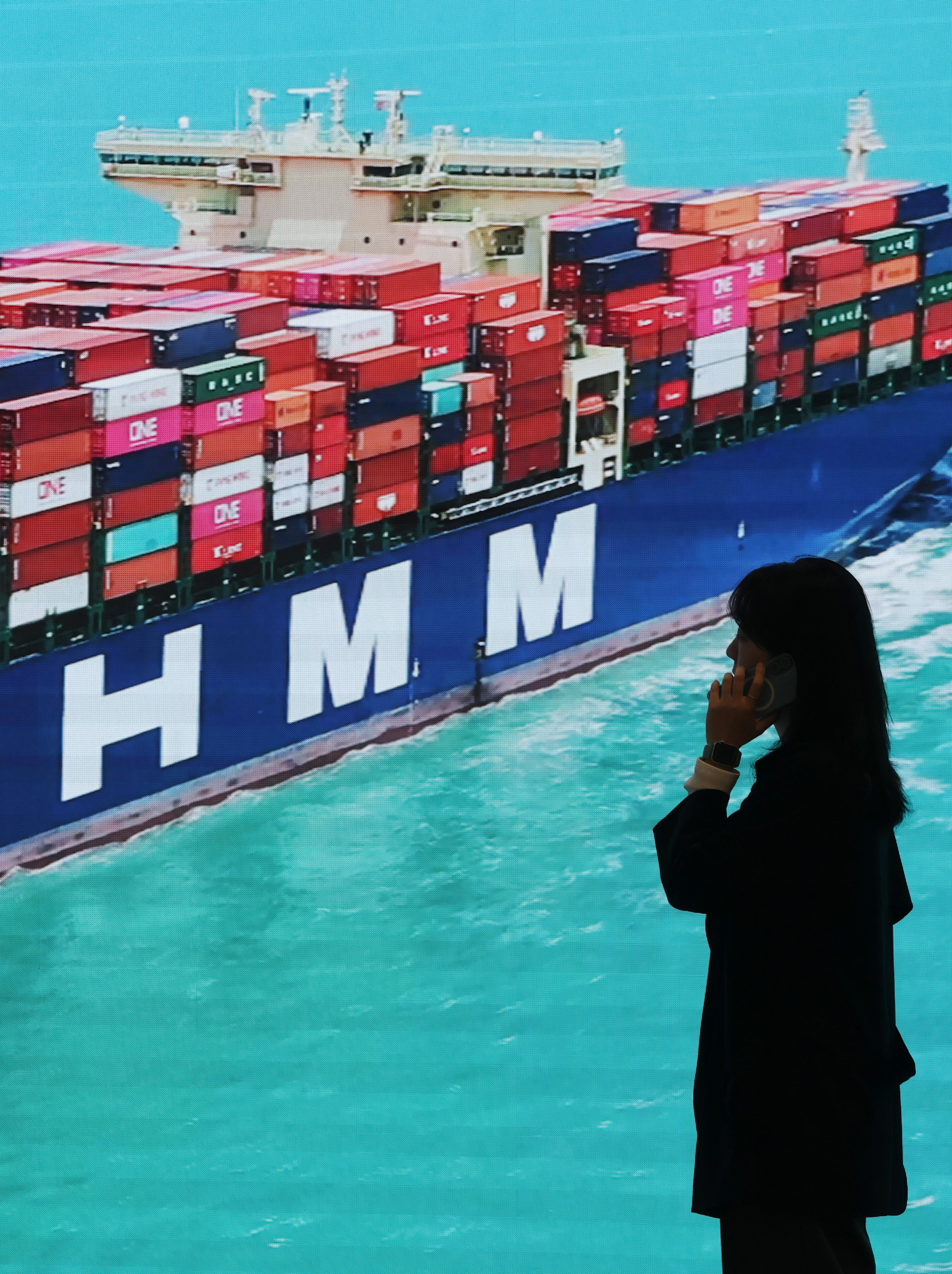 A person stands near a photograph in the headquarters of South Korean shipper HMM Co., in Seoul on Wednesday. Photo: EPA-EFE